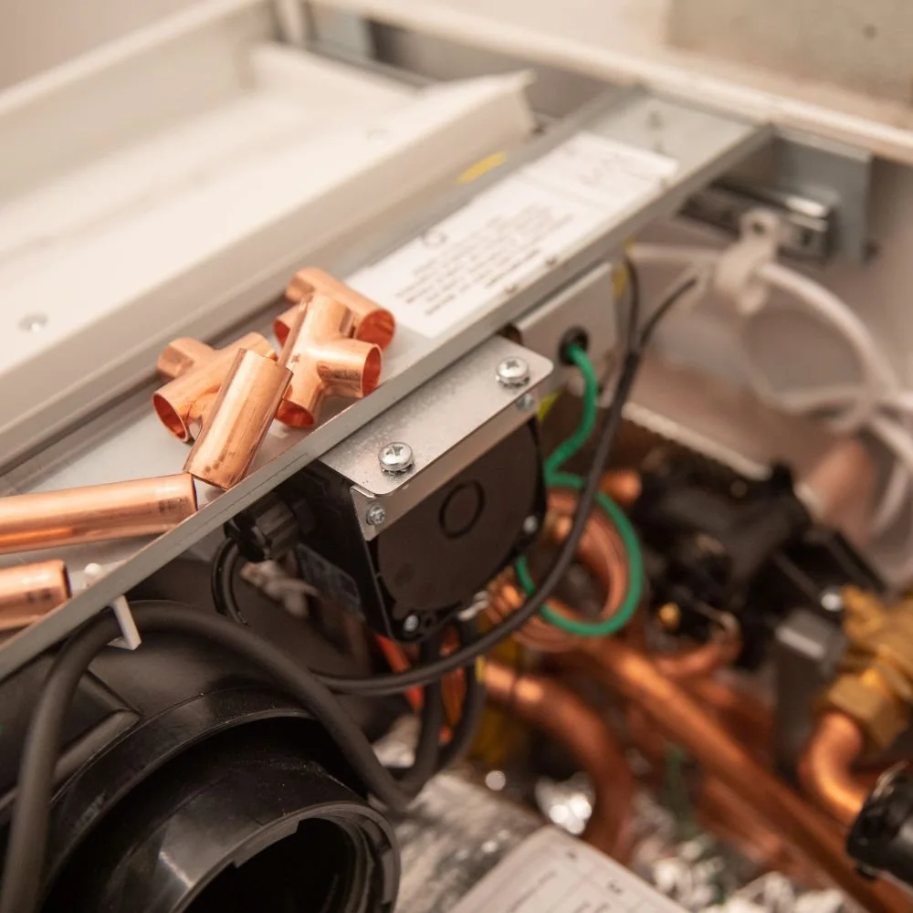 Close-up of an air conditioning or refrigeration unit with copper pipes and electrical components.