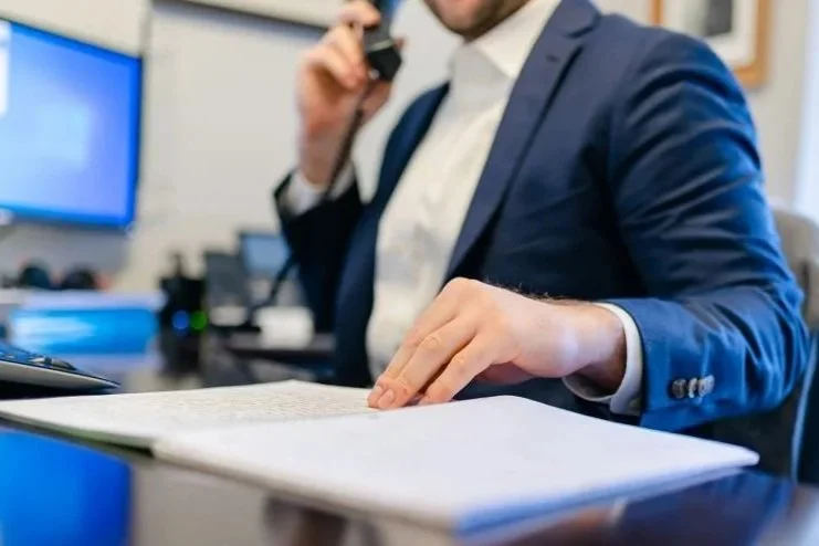 Professional on the phone reviewing documents