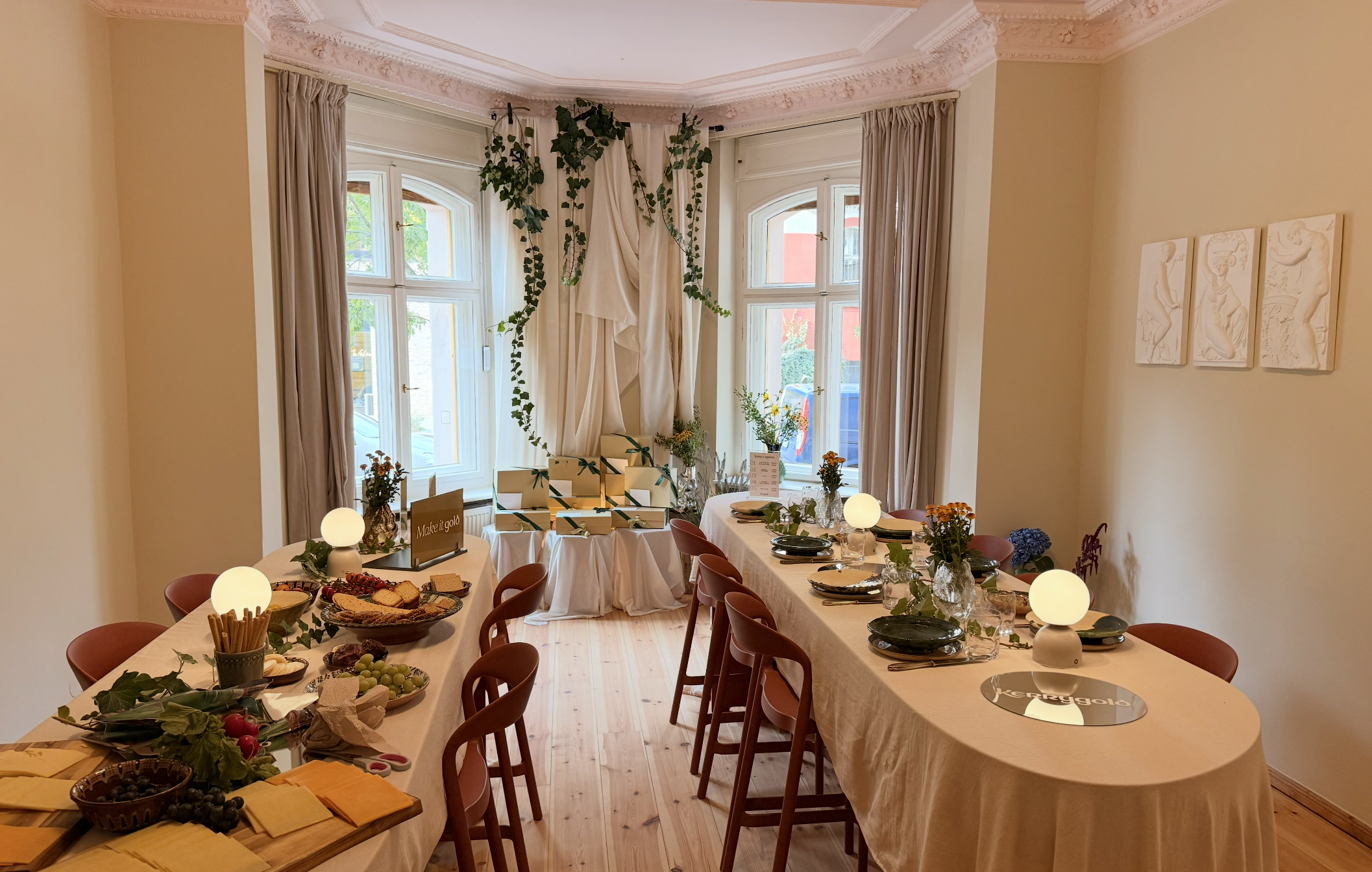 Ein festlich gedeckter Tisch mit Essen und Dekorationen in einem Raum mit großen Fenstern und weißen Wänden.