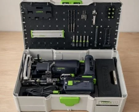 Open toolbox containing power tools, drill, and accessories, organized in compartments.