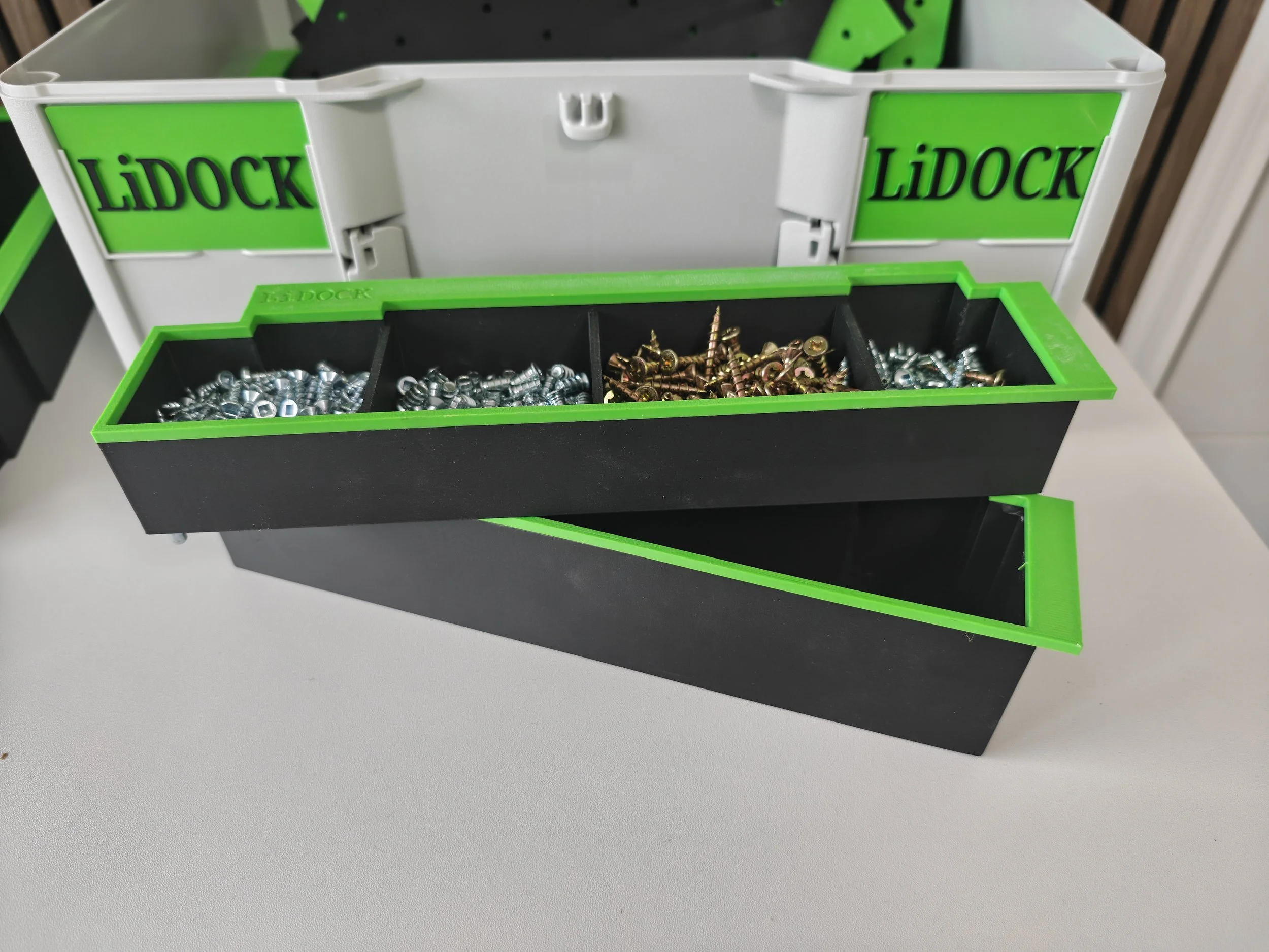 Plastic container with compartments filled with screws, nuts, and bolts, labeled 'LIDOCK' in green and black.