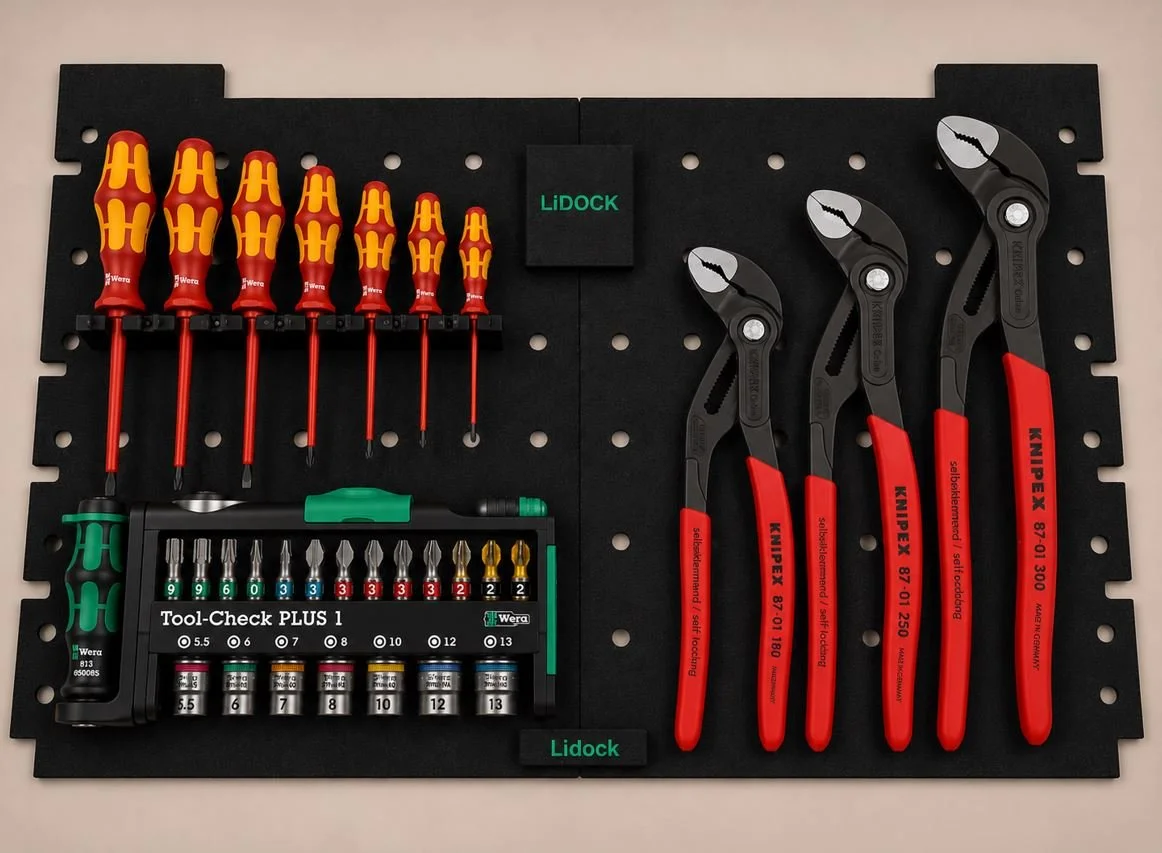 A black pegboard displaying screwdrivers, pliers, and bits, with labels for organization.