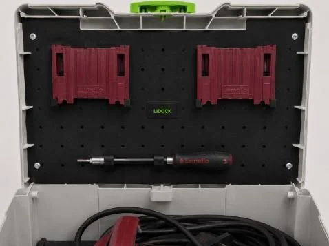 Open toolbox with two red clamps, a screwdriver, and a black power cord inside.