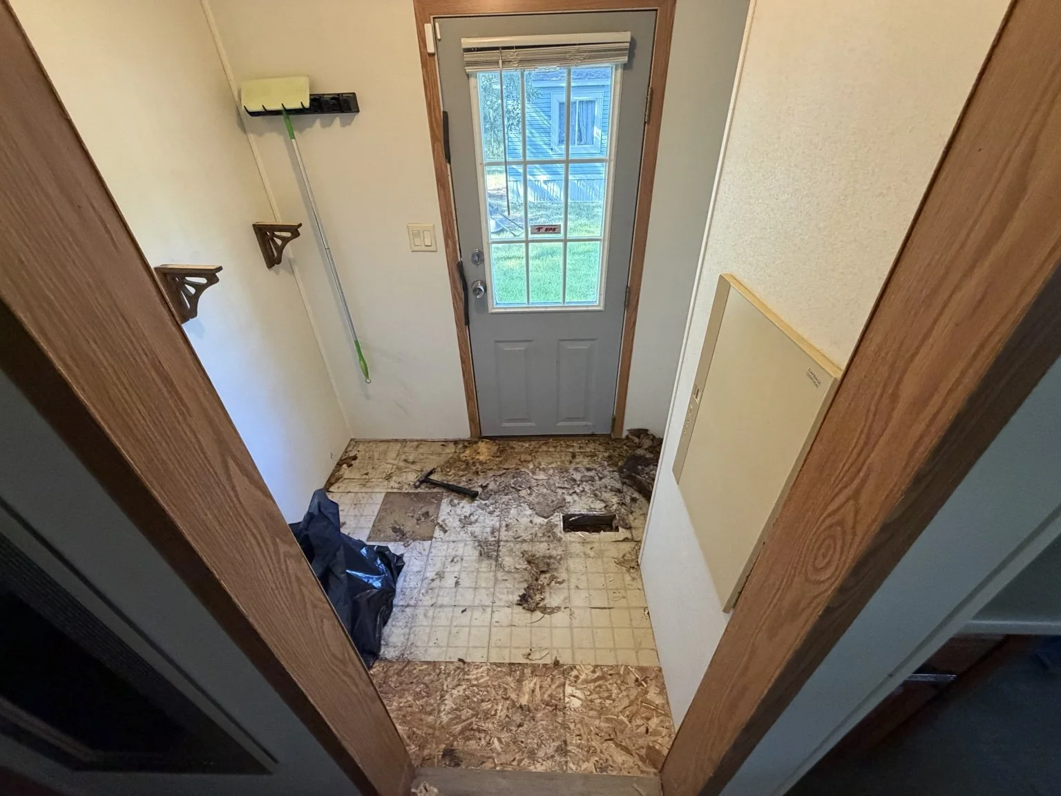 Damaged laundry-room subfloor exposed during the Twin Lake bathroom remodel