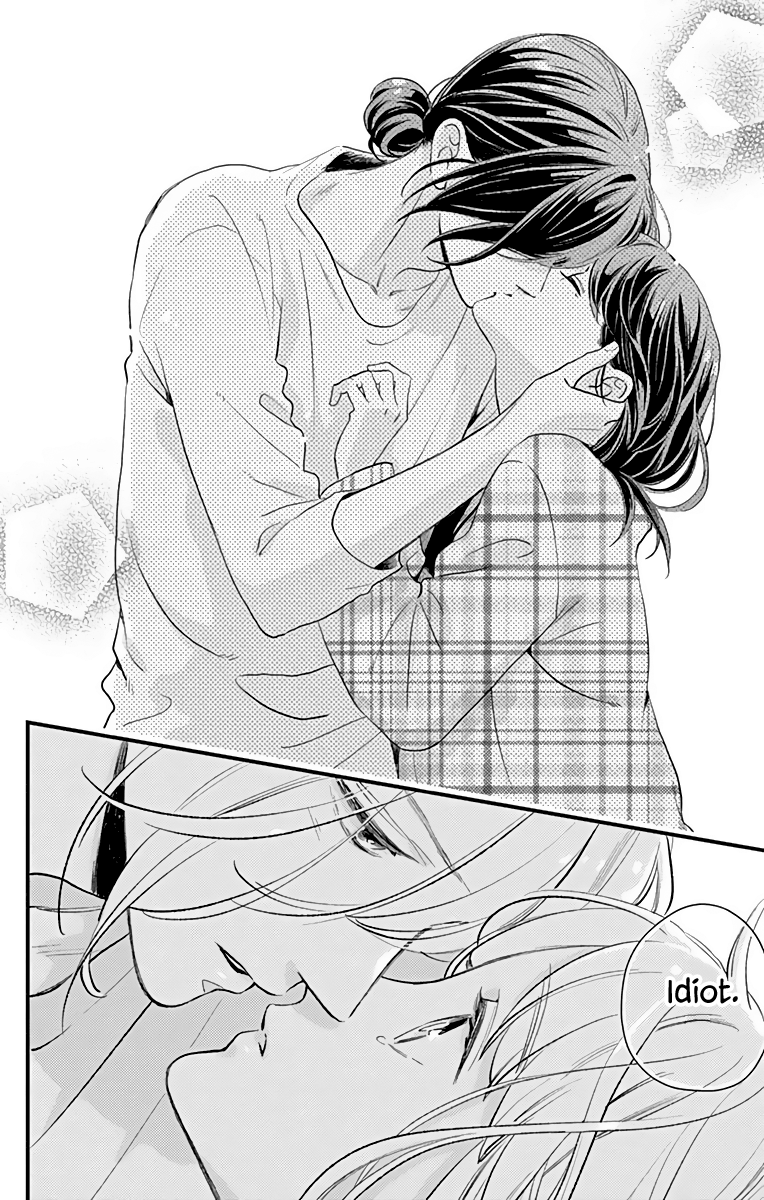 A manga-style black and white illustration of a romantic scene with a man and woman touching foreheads and a close-up of their faces with intense expressions. The woman has long, wavy hair and is wearing a plaid shirt, while the man has medium-length hair. They are engaged in an emotional moment, with a speech bubble that says "Idiot."