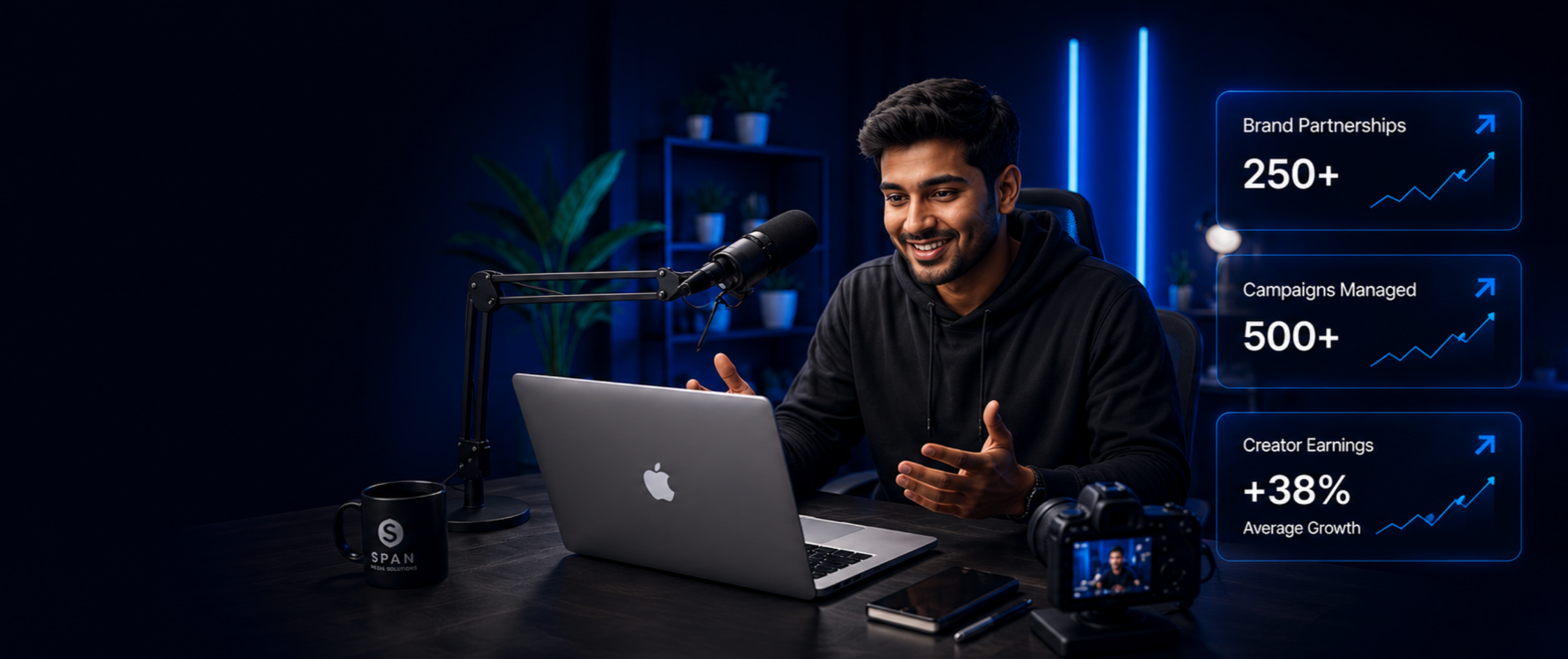 A man in a black hoodie sitting at a desk with a silver MacBook, microphone, camera, and coffee mug, recording a podcast or video in a dark room with blue lighting and potted plants. Overlaid in the image are digital statistics showing growth in brand partnerships, campaigns managed, and creator earnings.