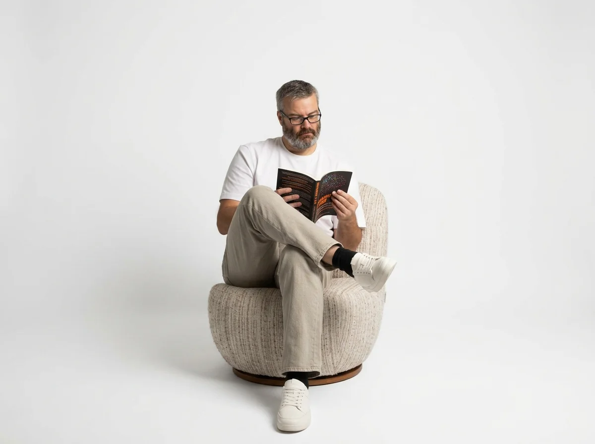 ADHD Coach Chris sitting on chair reading neurodiversity at work book