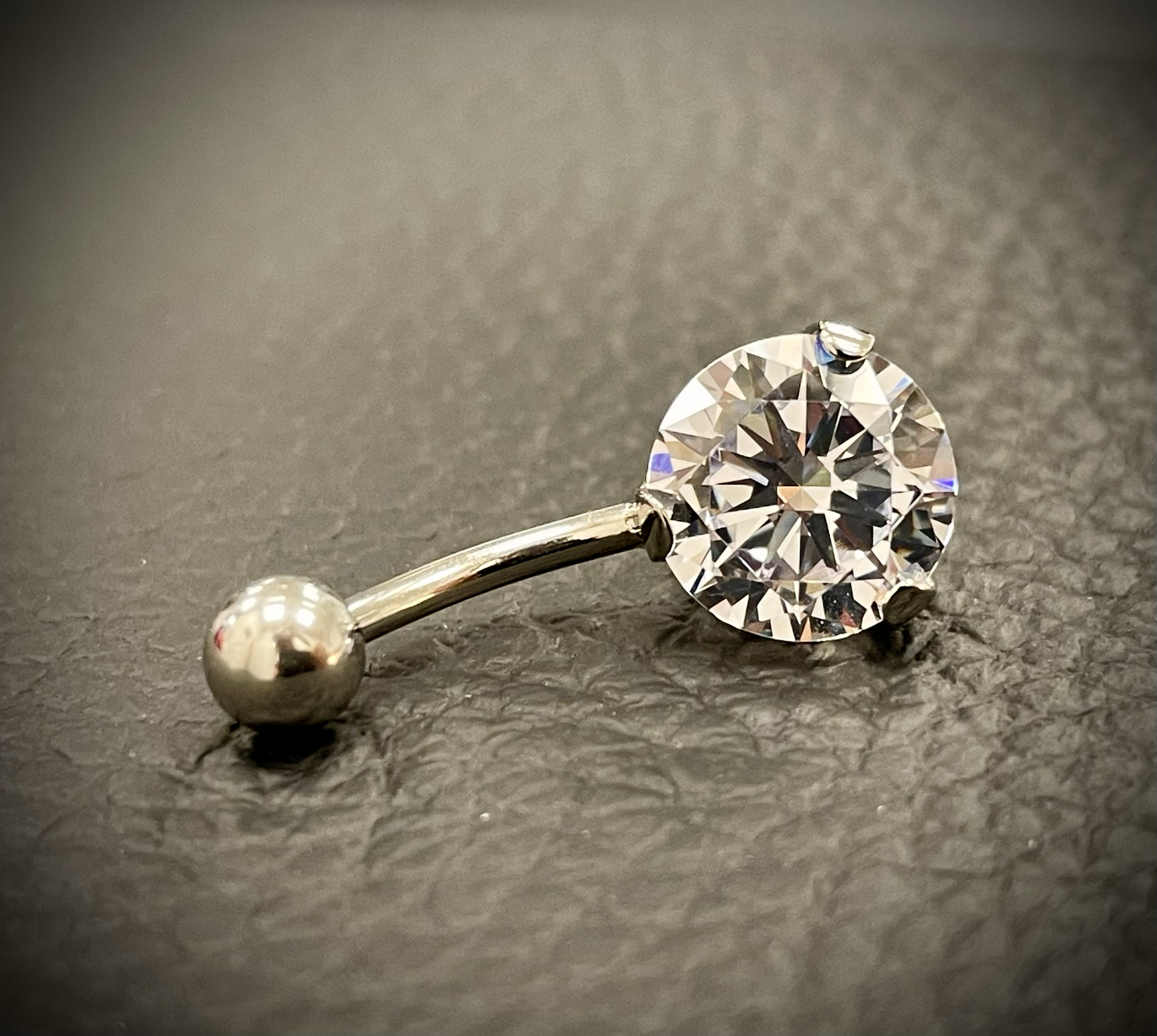 Nahaufnahme eines diamantenen Edelsteins auf einer schwarzen Oberfläche.
