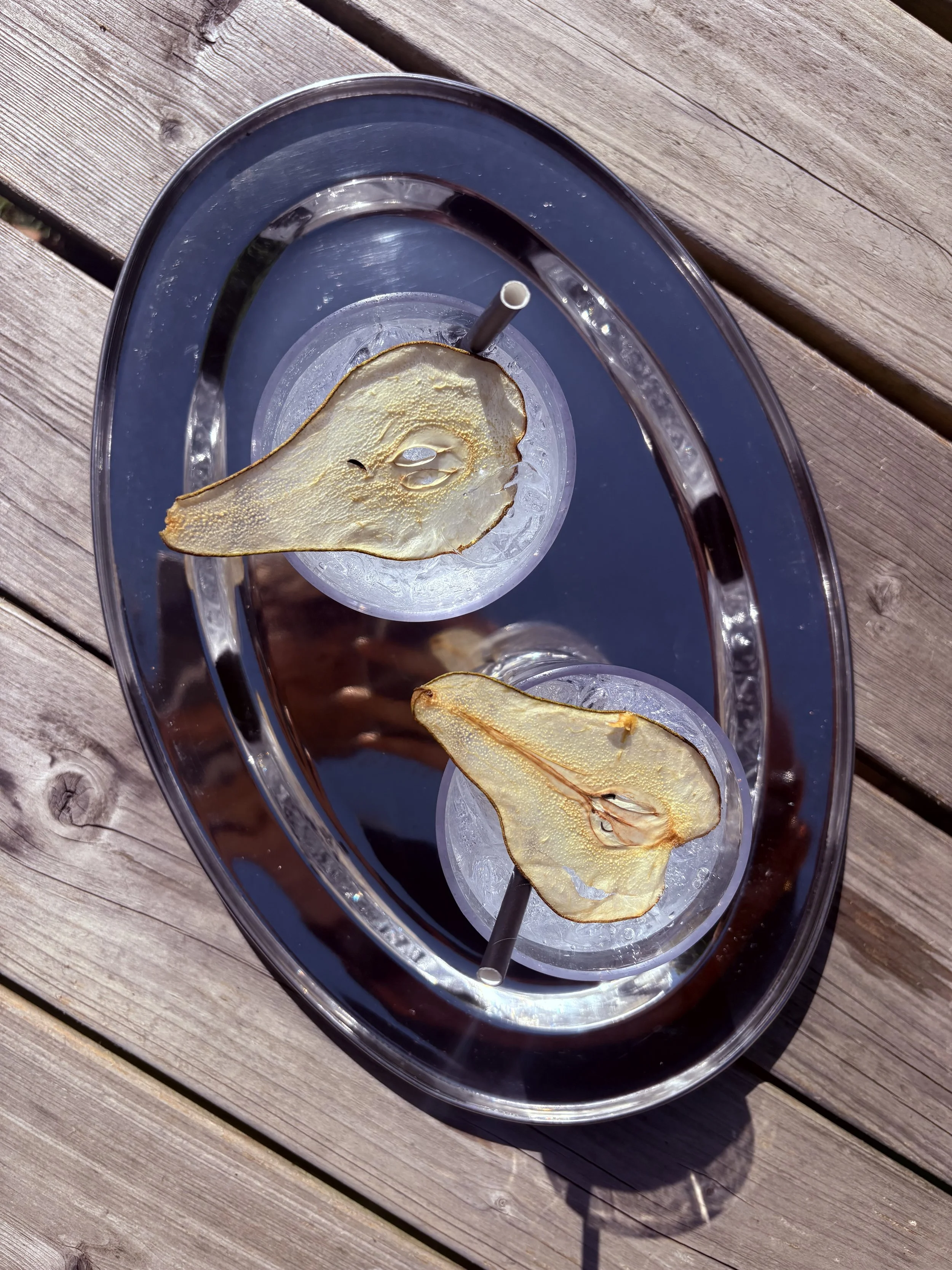 Een leeg glas met een rietje en een gedroogde walnoot op een houten tafel.