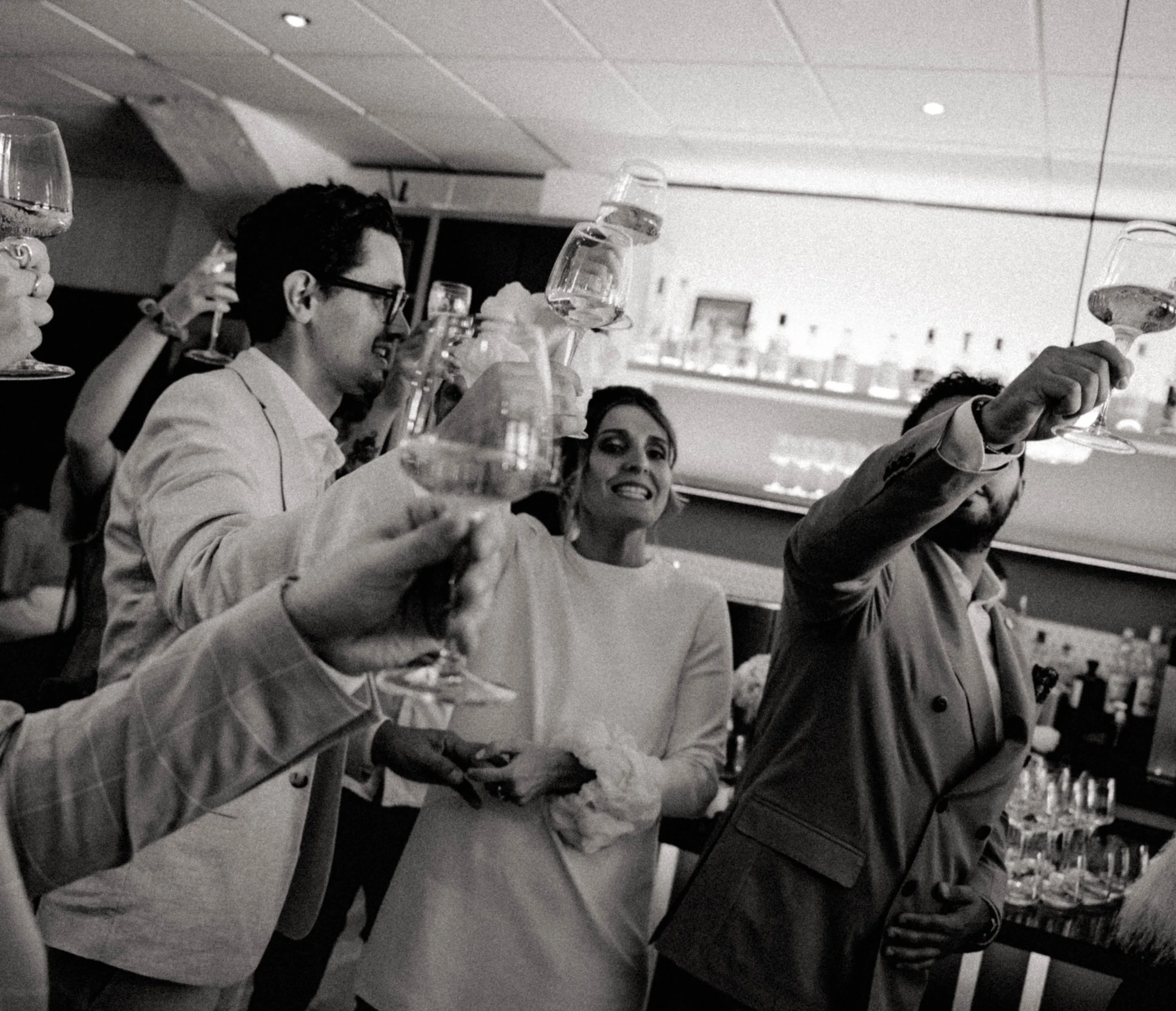 Groupe de personnes célébrant avec des verres à vin dans une ambiance festive.