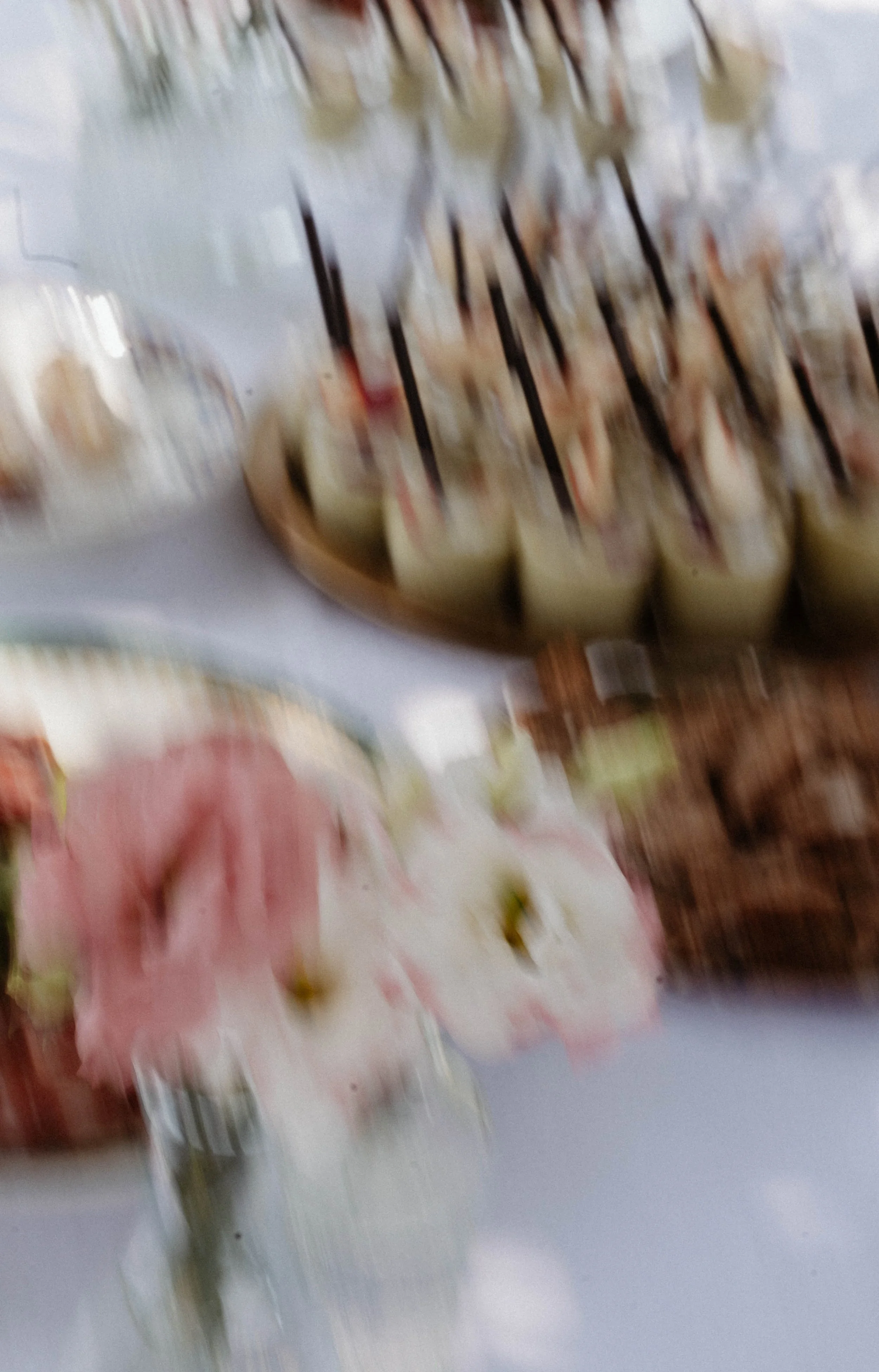 Une assiette contenant des sushis. Le fond montre un autre plat avec de la charcuterie.