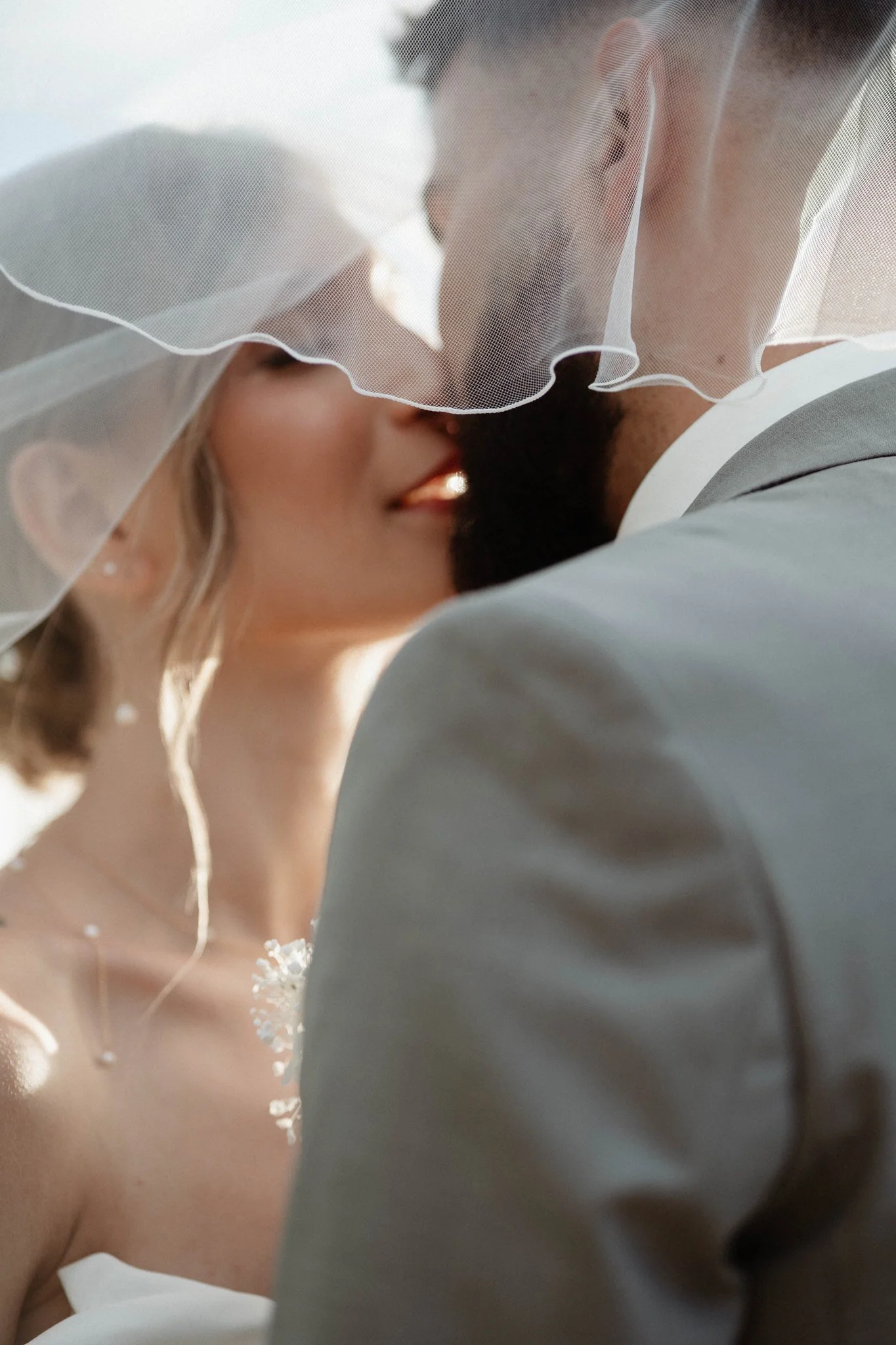 Un couple en vêtements de mariage partage un baiser.
