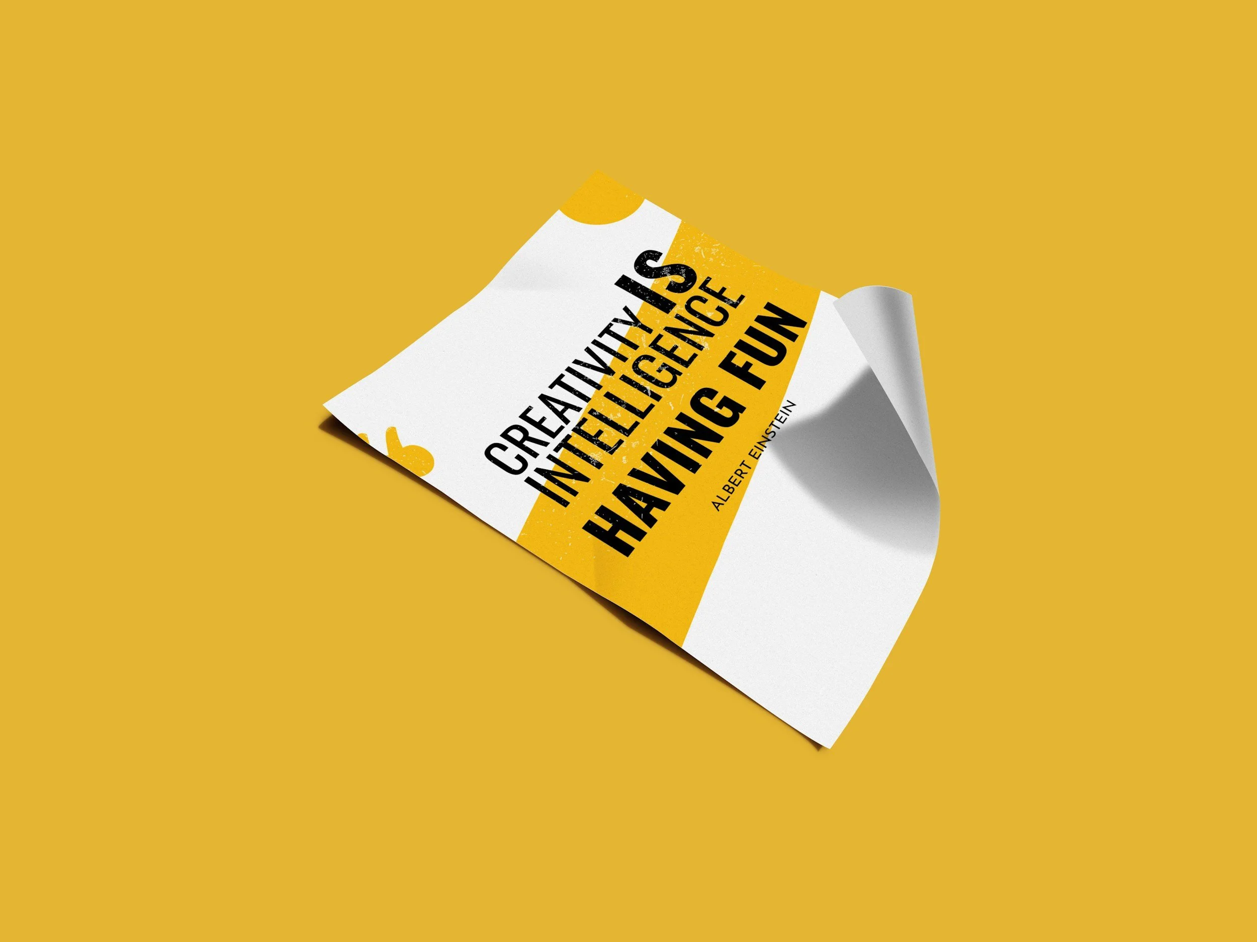 A yellow background with a crumpled white paper featuring black and yellow text that reads 'Creativity is intelligence having fun,' attributed to Albert Einstein.