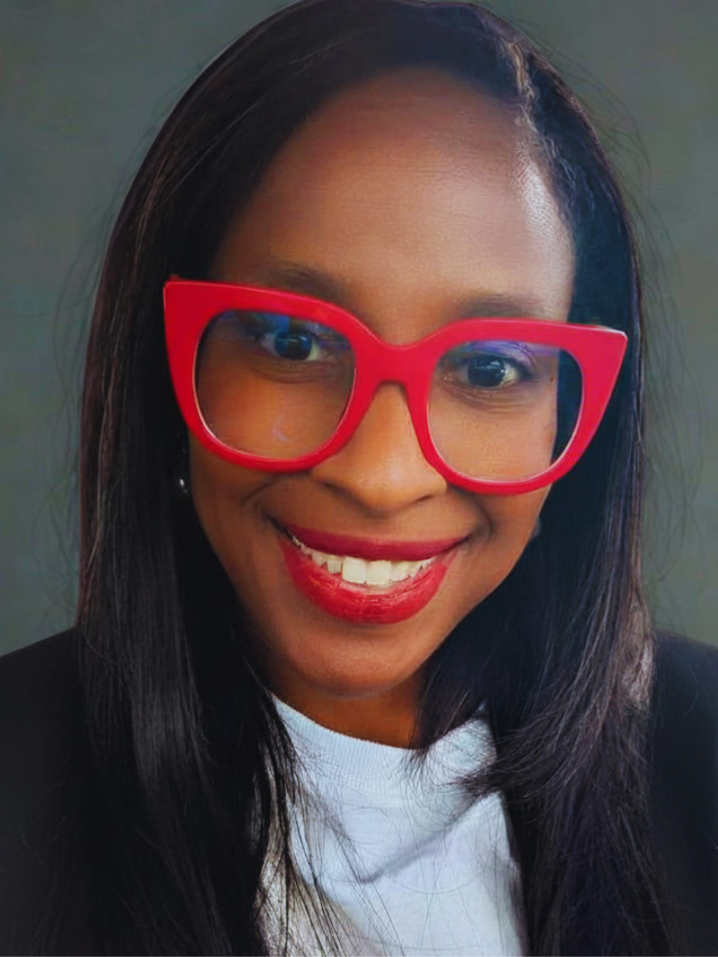 A woman with straight black hair wearing red glasses, smiling, and showing her teeth.