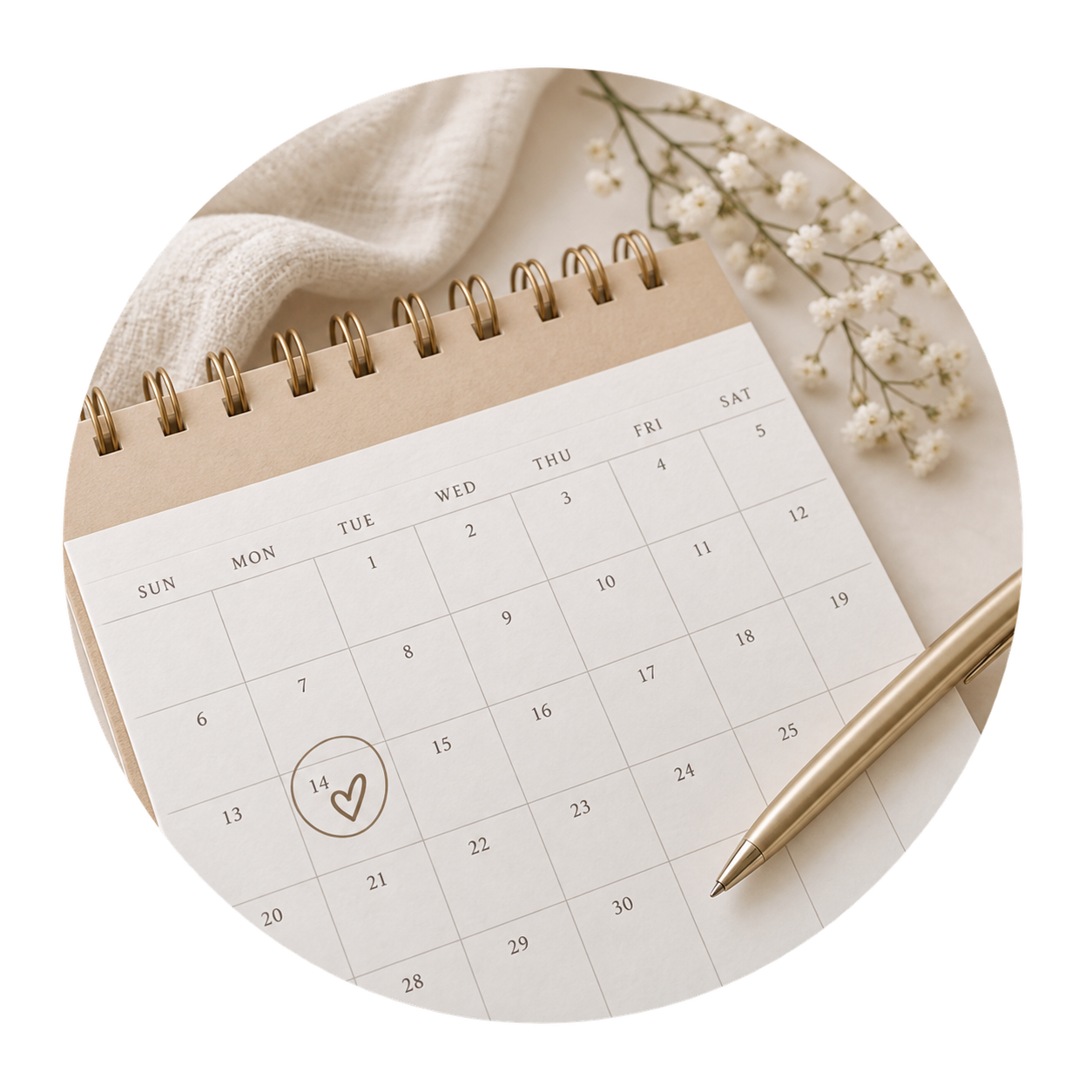 A calendar page open to the month of February, with the 14th circled and marked with a heart. Next to the calendar is a beige pen, and there are small white flowers and a beige cloth nearby.