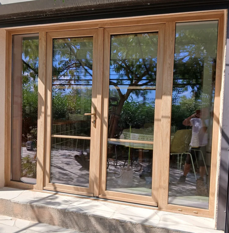 Porte-fenêtre PVC à quatre vantaux imitation bois avec petits bois intégrés au double vitrage, réalisation Menuiserie Mellin à Bagnols-en-Forêt