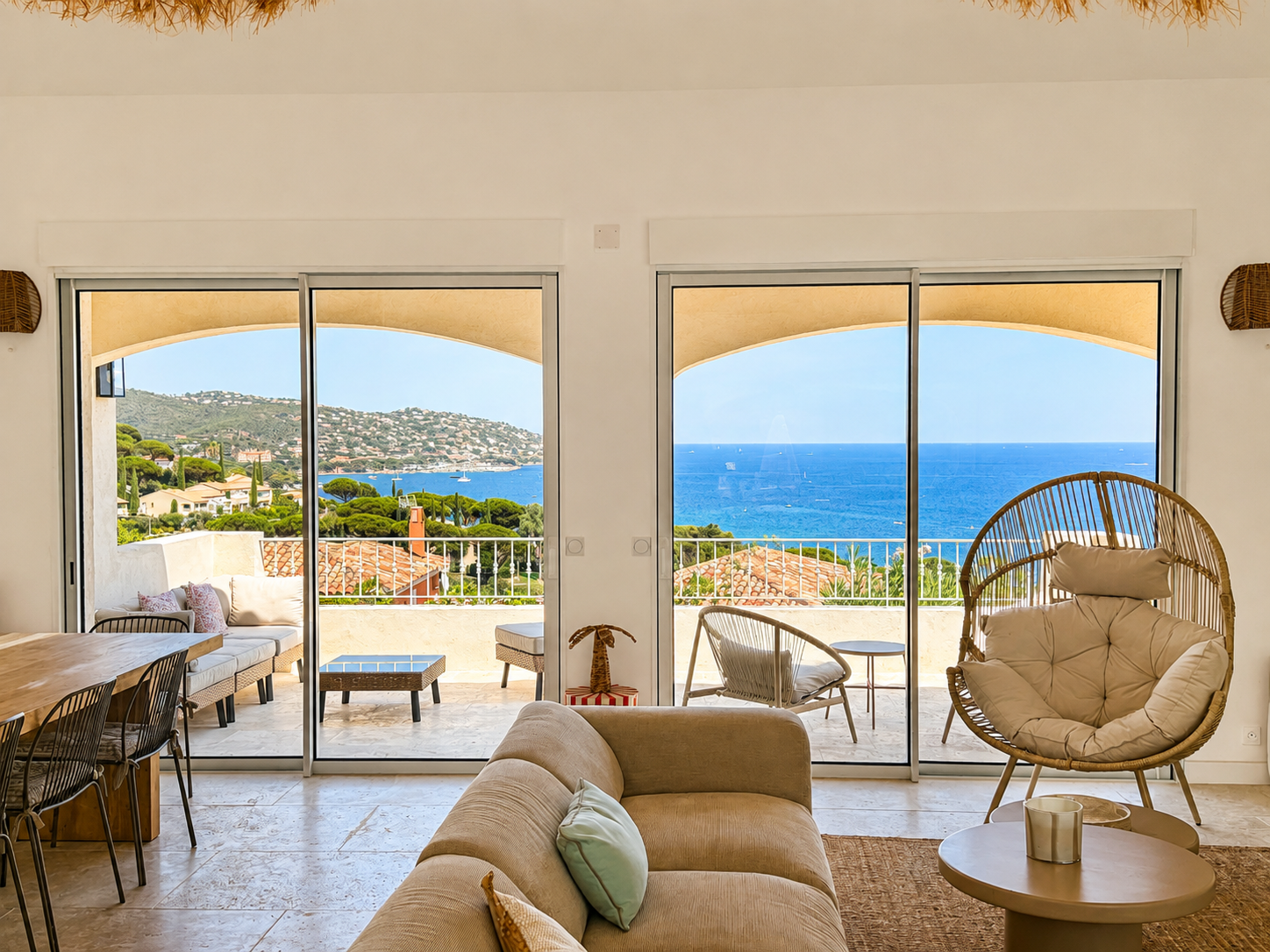 Grande baie coulissante en aluminium ouvrant un séjour sur une terrasse avec vue sur la mer