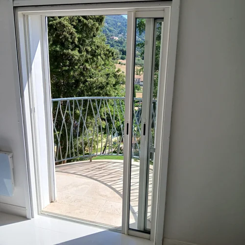 Baie coulissante à galandage en aluminium blanc à deux vantaux, réalisation Menuiserie Mellin à Fayence