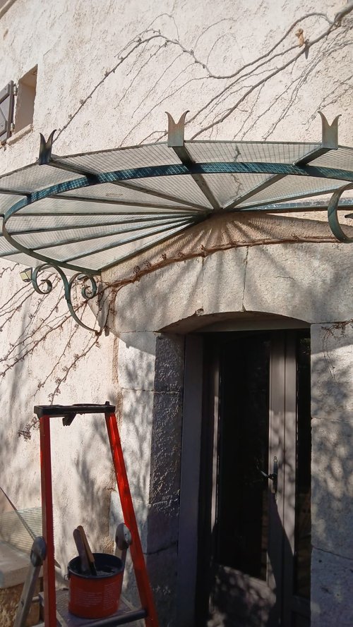Remplacement du vitrage d’une marquise en fer forgé au-dessus d’une porte d’entrée en pierre