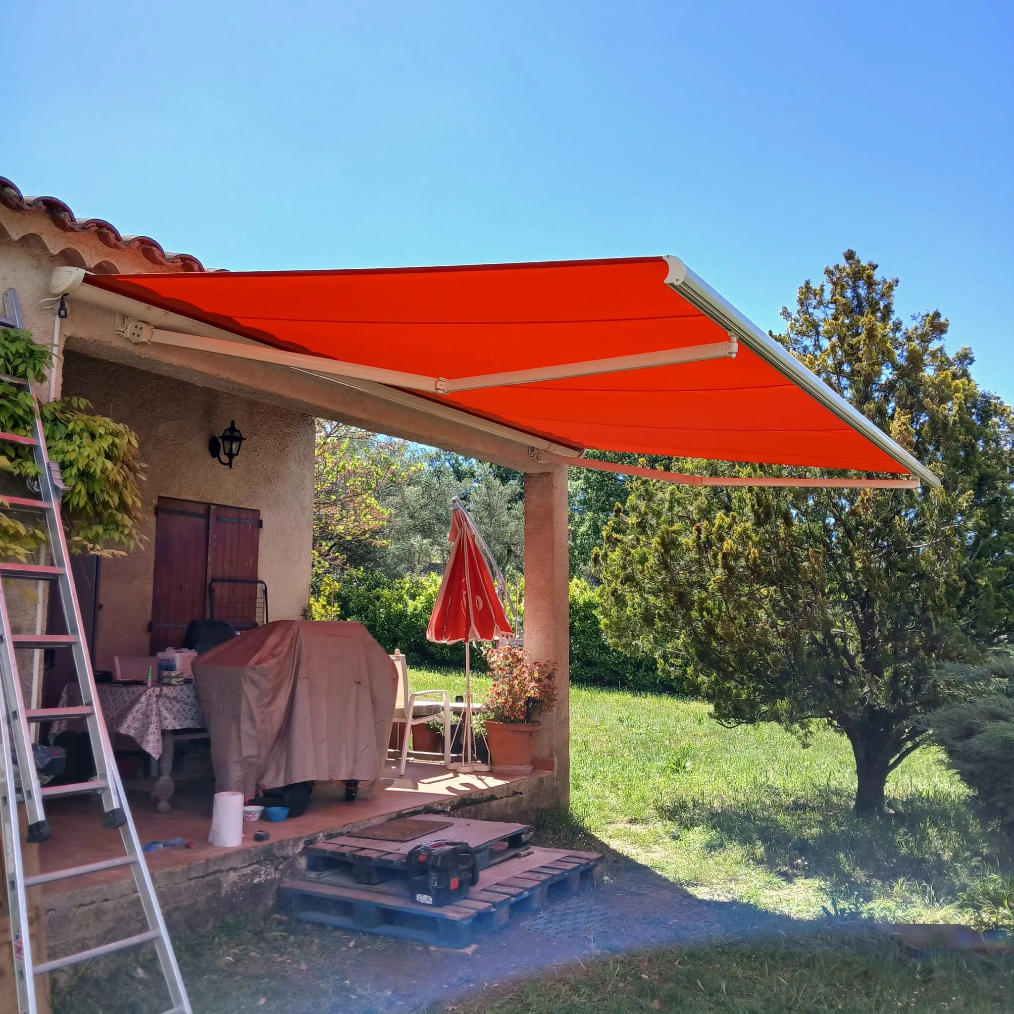 Store banne rouge sur une terrasse — Miroiterie Menuiserie Mellin, Pays de Fayence