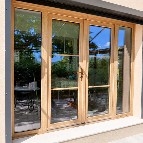 Porte-fenêtre PVC à quatre vantaux couleur bois avec petits bois intégrés au double vitrage, réalisation Menuiserie Mellin à Montauroux