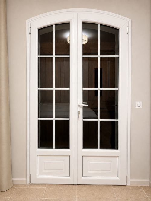 Porte-fenêtre PVC blanche cintrée avec petits bois intégrés au double vitrage et serrure en soubassement, réalisation Menuiserie Mellin à Montauroux