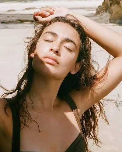 Portrait of a woman in sunlight at the beach.