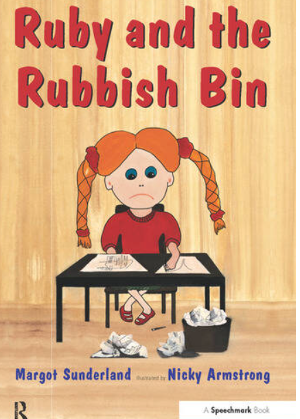 Book cover titled 'Ruby and the Rubbish Bin' showing a girl with orange braided hair, sitting at a desk with trash around her, with a wooden background.