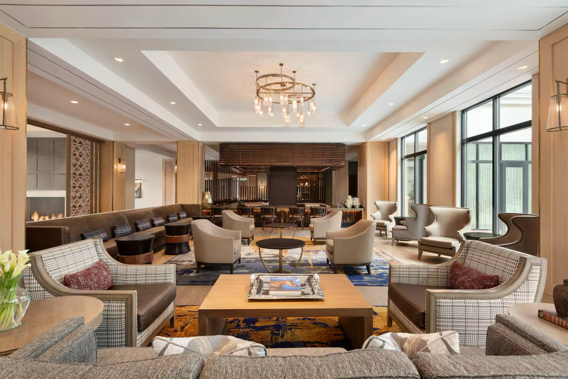 Luxurious hotel lounge with modern furniture, large windows, and elegant lighting fixtures.