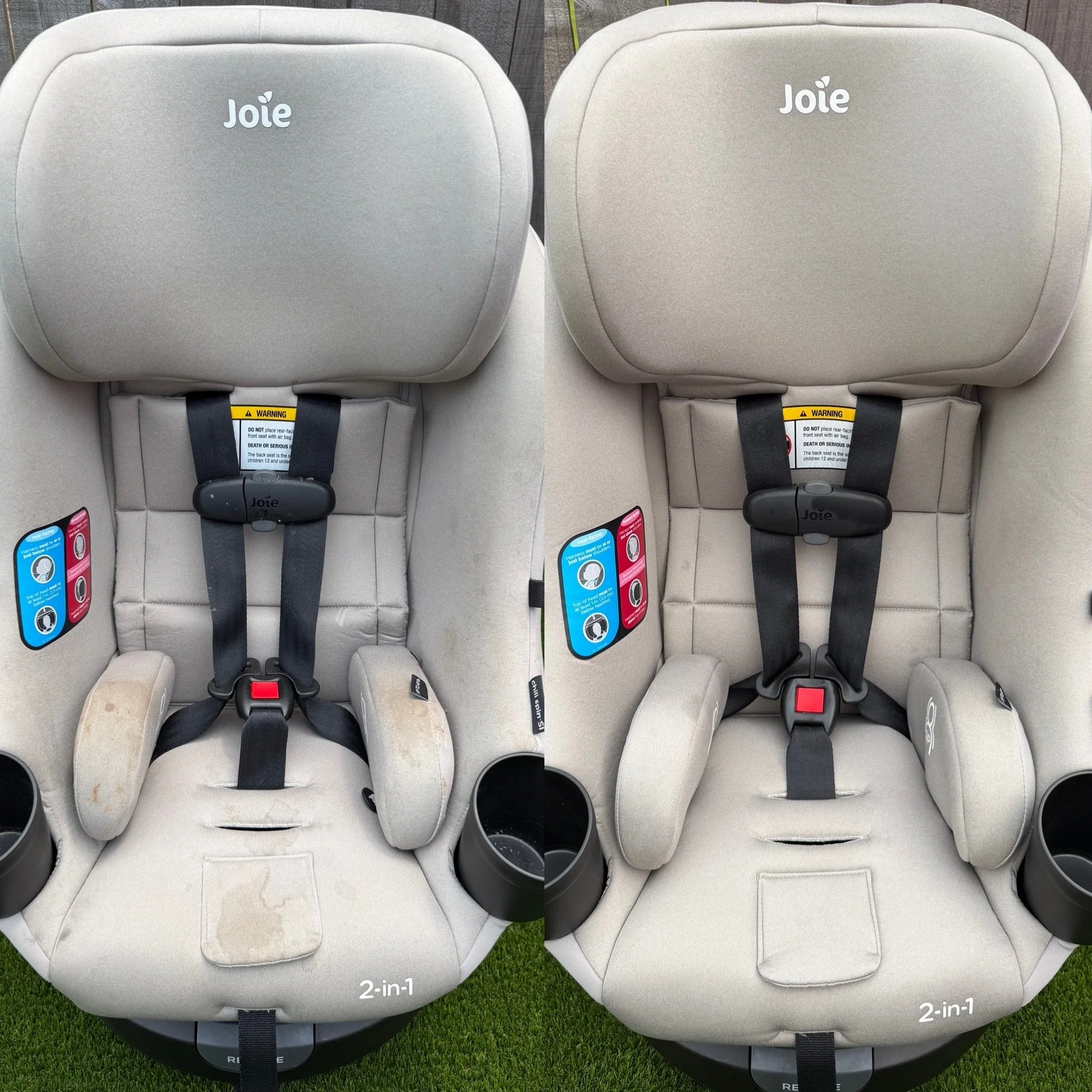 Two beige baby car seats side by side, labeled "2-in-1," with black safety harnesses and warning labels, placed on a grassy surface with a wooden fence in the background.