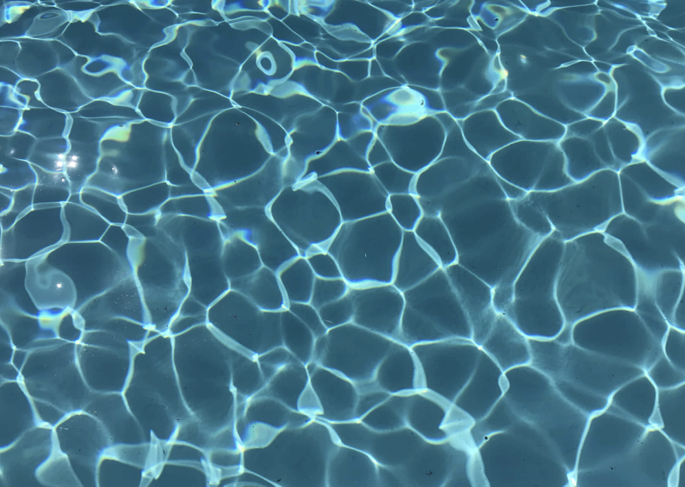Water surface with light reflections creating a pattern of bright lines and shapes.
