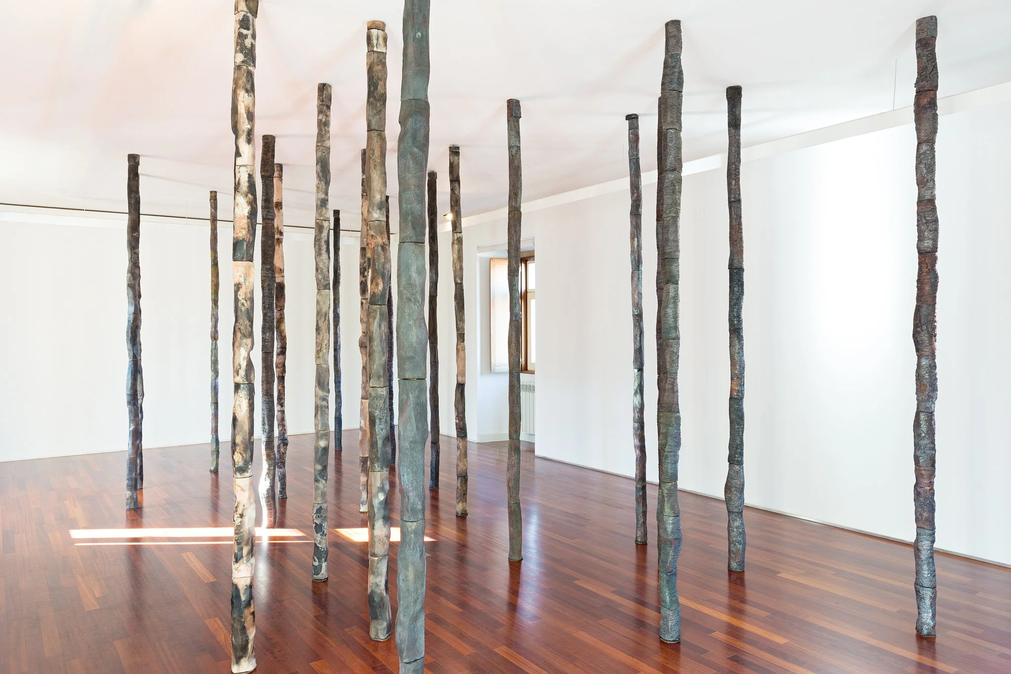 Saggar and raku fired at 1000ºC with oxides and glazes. 50 columns arranged as a forest, 10 x 10 x 300 (cm) aprox. for each column