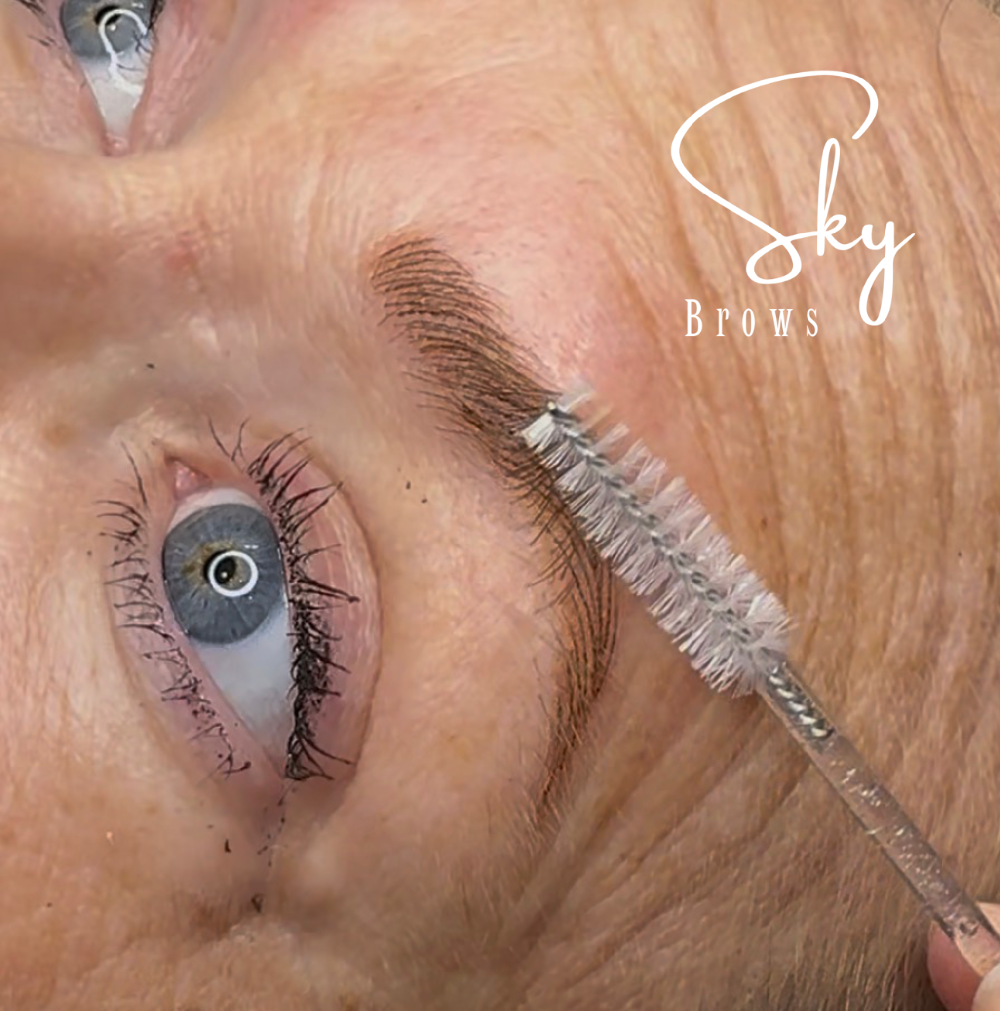 Close-up of a person's eyebrow, eyelash, and eye with white eyeliner, with the words 'Okay Brows' written in white cursive text over the eyebrow area.