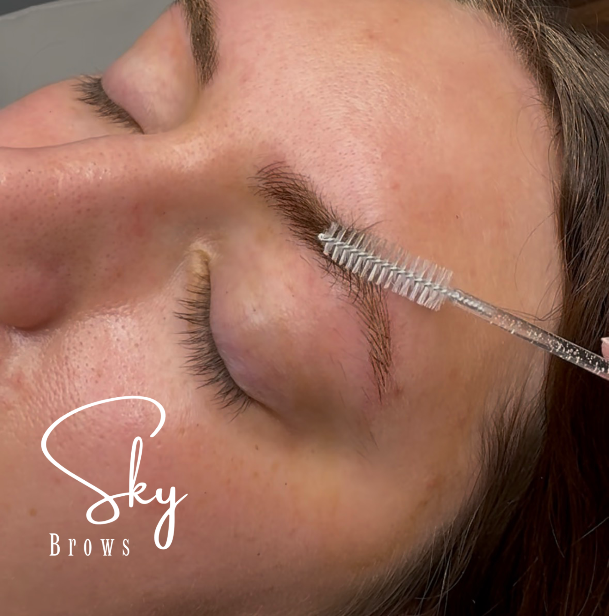 Close-up of a person's face with closed eyes, focusing on eyebrows with the words 'Sky Brow Brows' overlaid in white script.