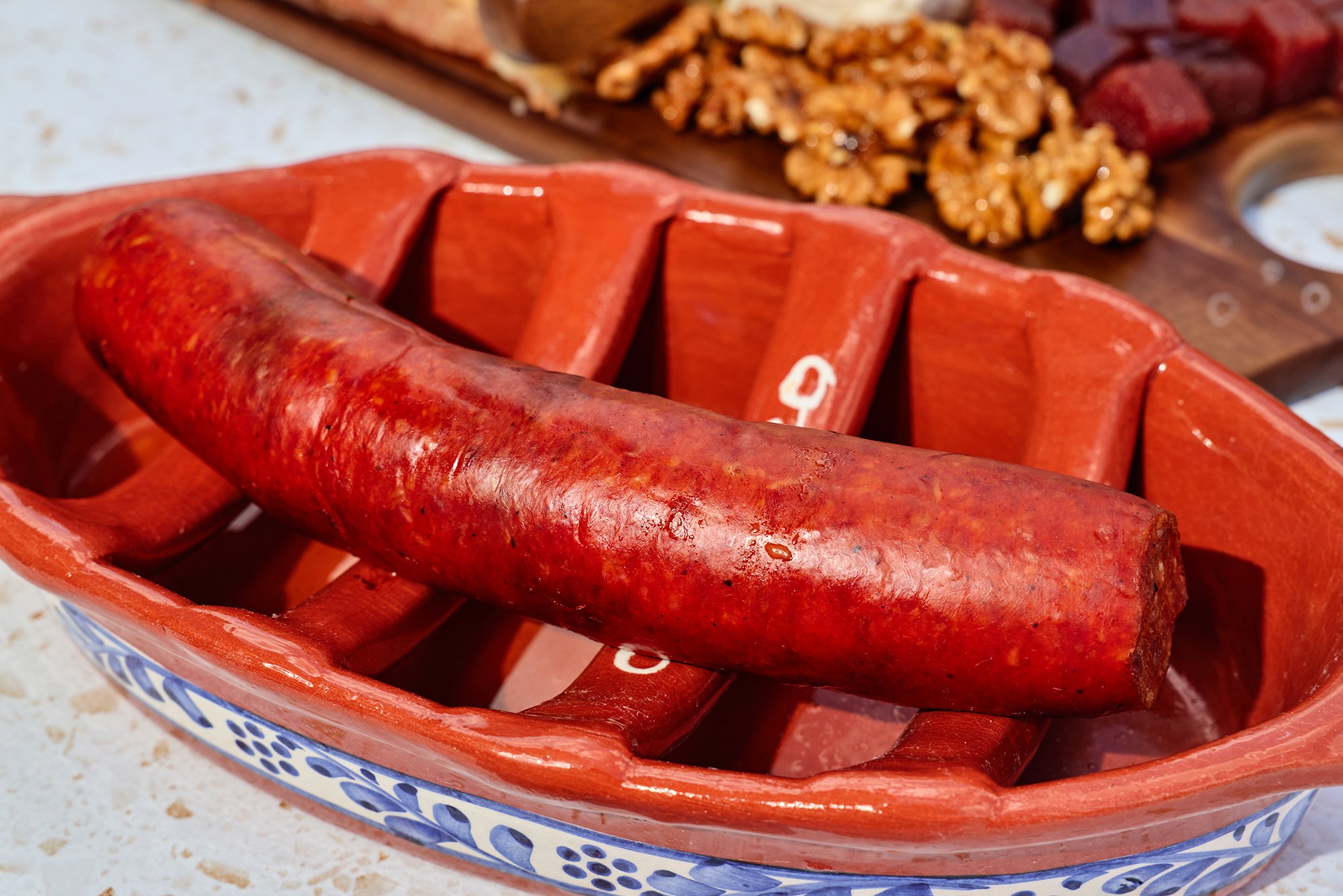 Red chili peppers in a ceramic basket with a patterned blue rim.