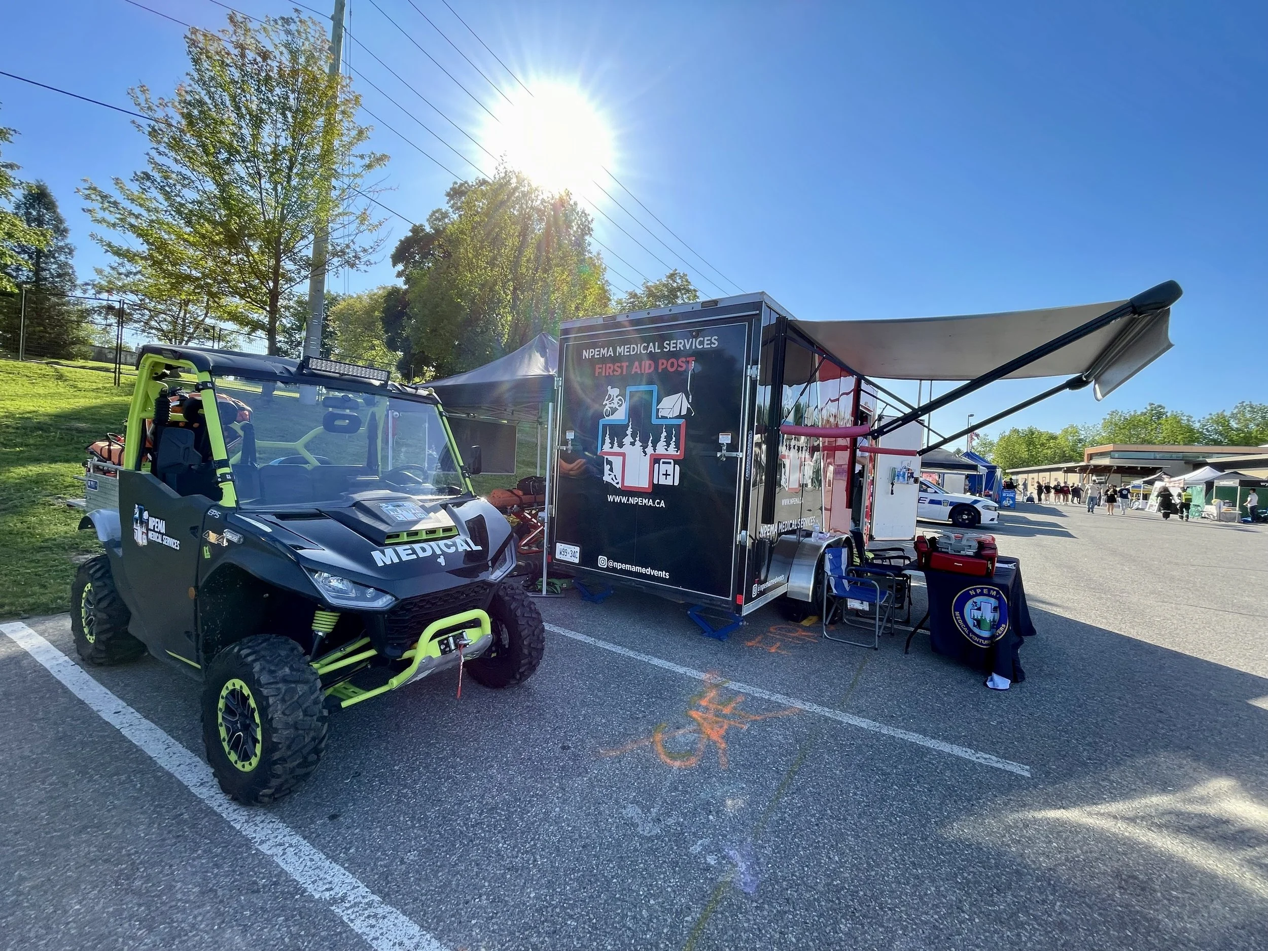 NPEMA Medical Services first aid post with an off-road medical vehicle and treatment trailer at an outdoor event