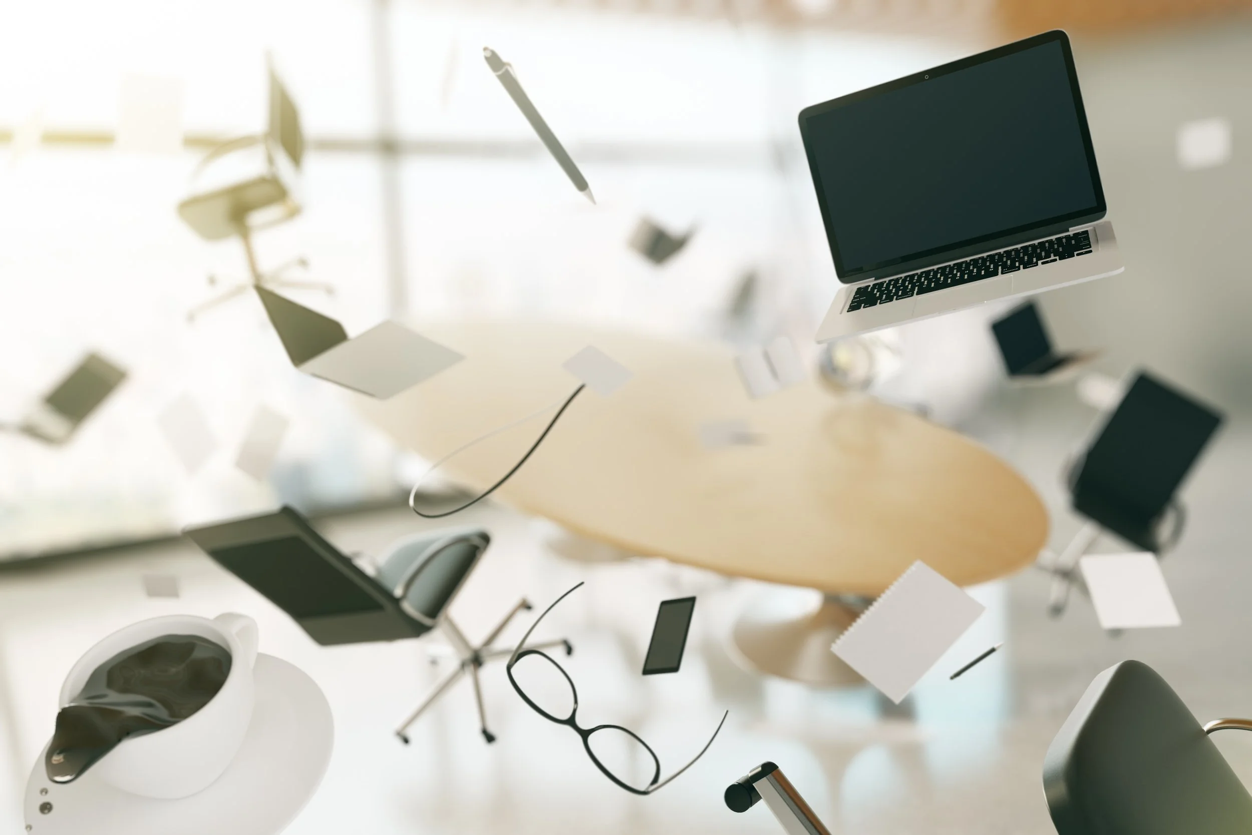 An office with chairs, a round table, charging cables, a laptop, eyeglasses, a coffee cup, and other office items suspended in midair.