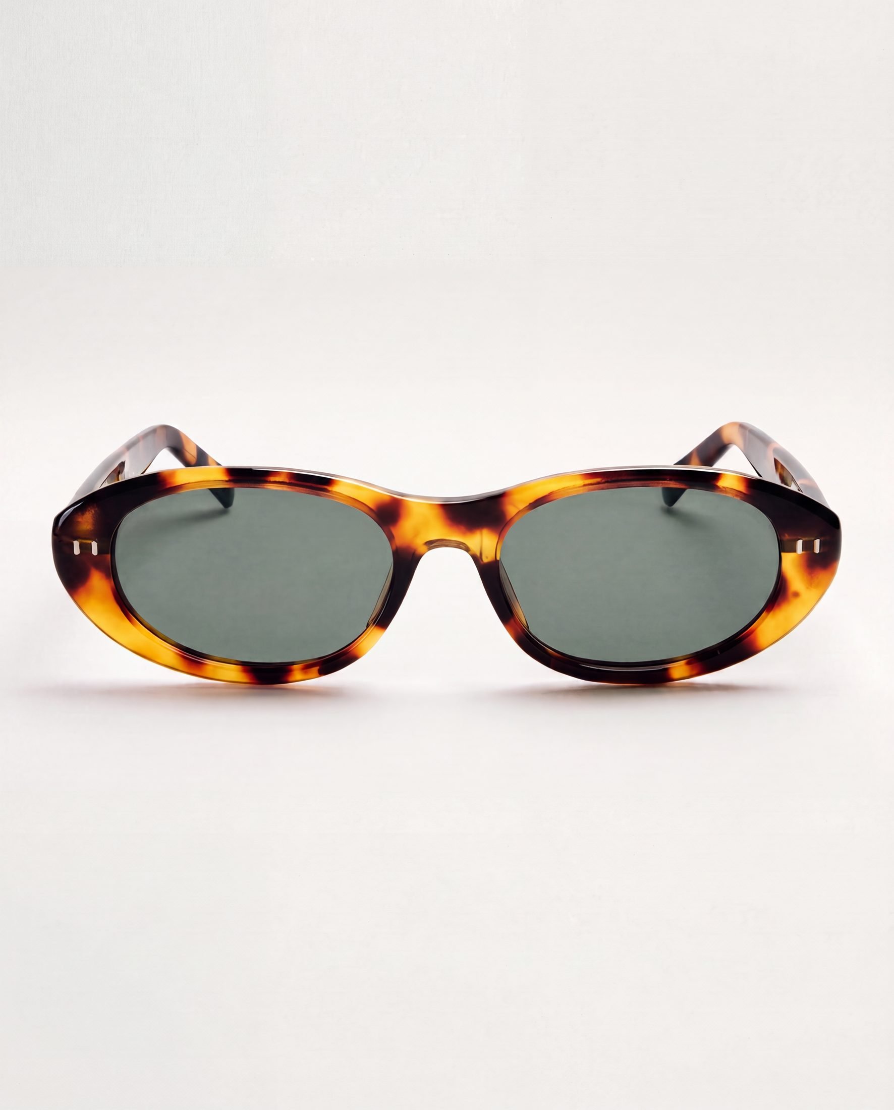 A pair of tortoiseshell sunglasses with dark lenses on a white background.