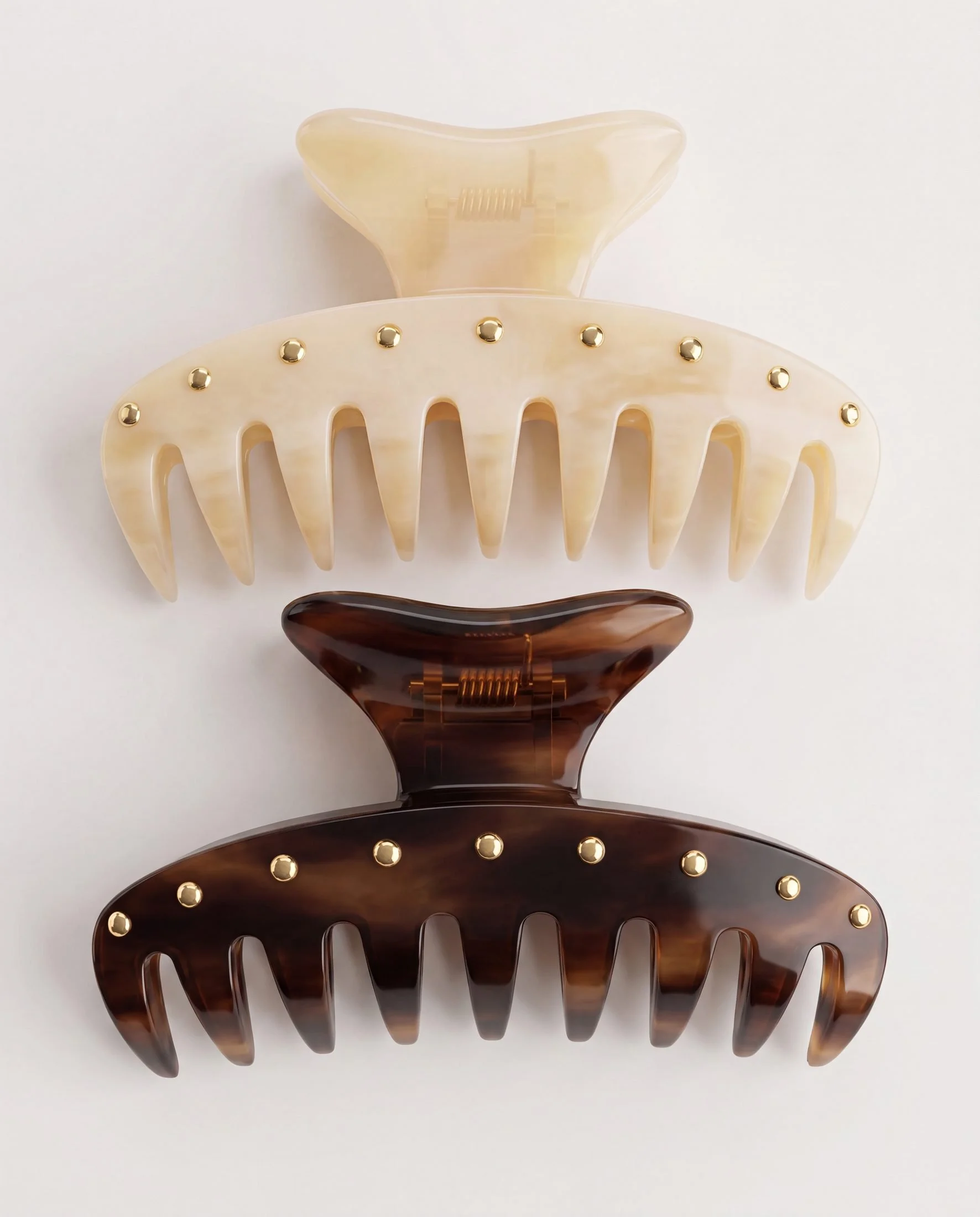A set of four hair claw clips in different colors and patterns arranged vertically on a plain white background.