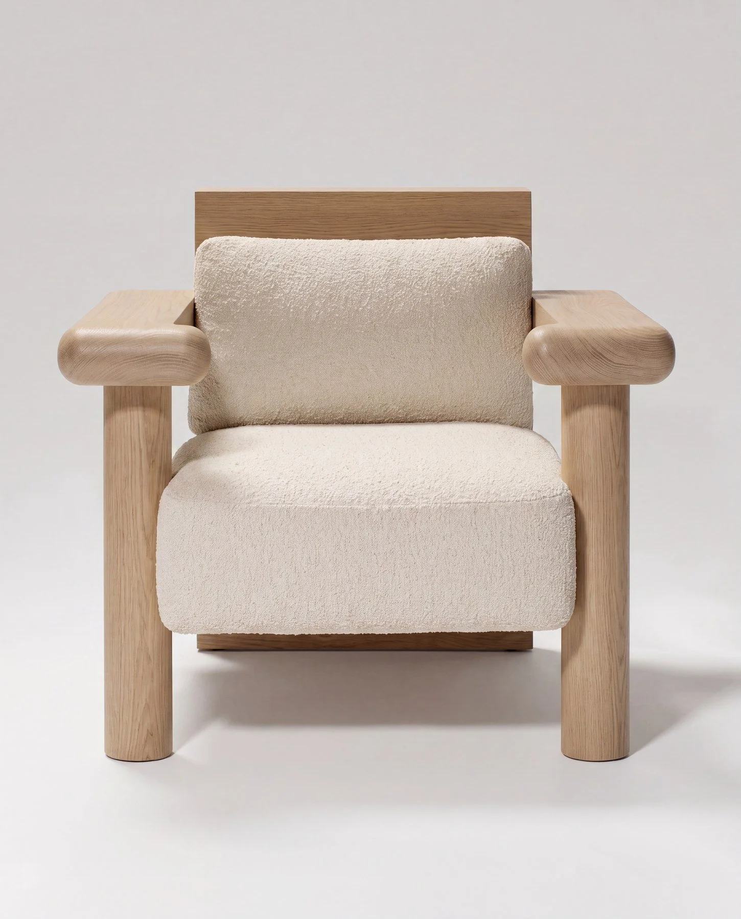 A modern armchair with a wooden frame and off-white fabric cushions set against a plain white background.