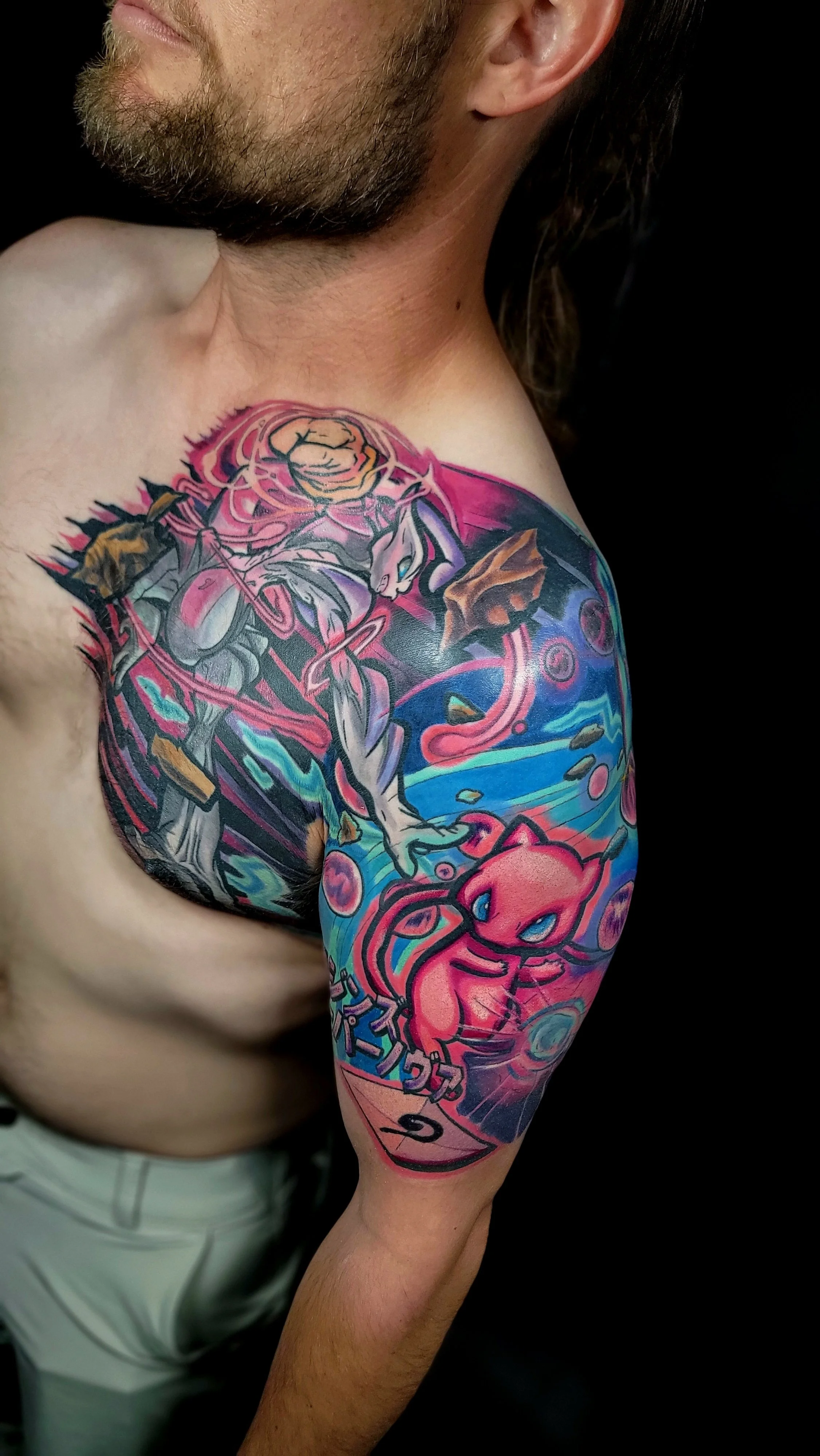 Colorful tattoo sleeve featuring a ninja character, a pink Sonic the Hedgehog character, and abstract background elements on person's upper arm and shoulder.