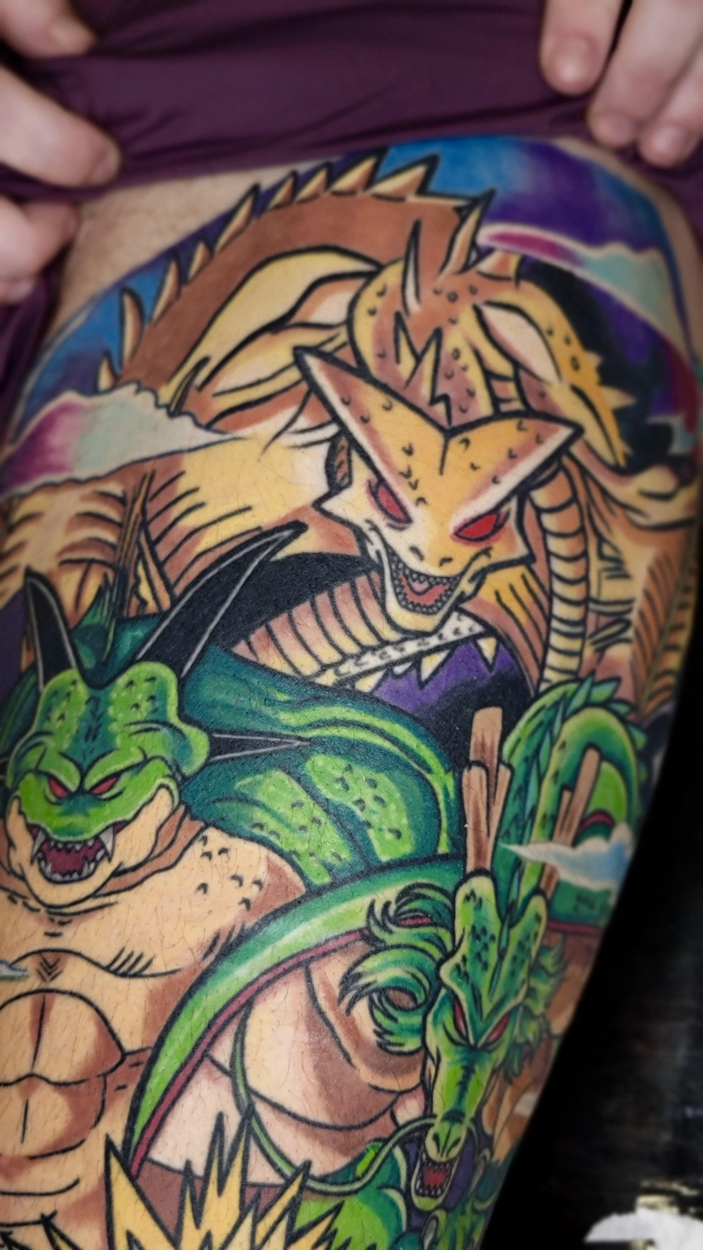Colorful tattoo of a dragon and a snake on someone's arm.