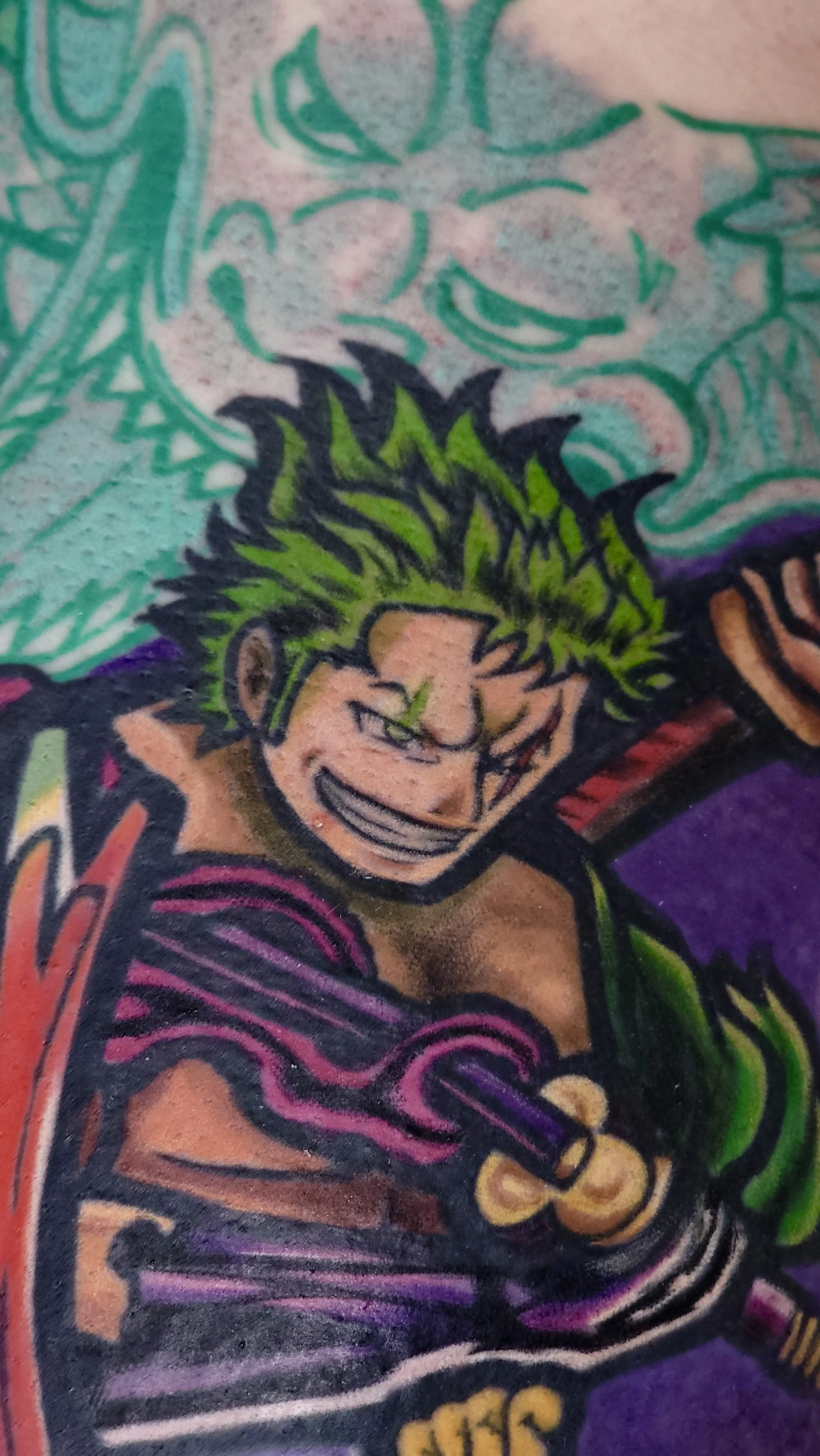 Colorful tattoo of a cartoon comic character with green hair, a mischievous grin, and a purple-striped shirt.