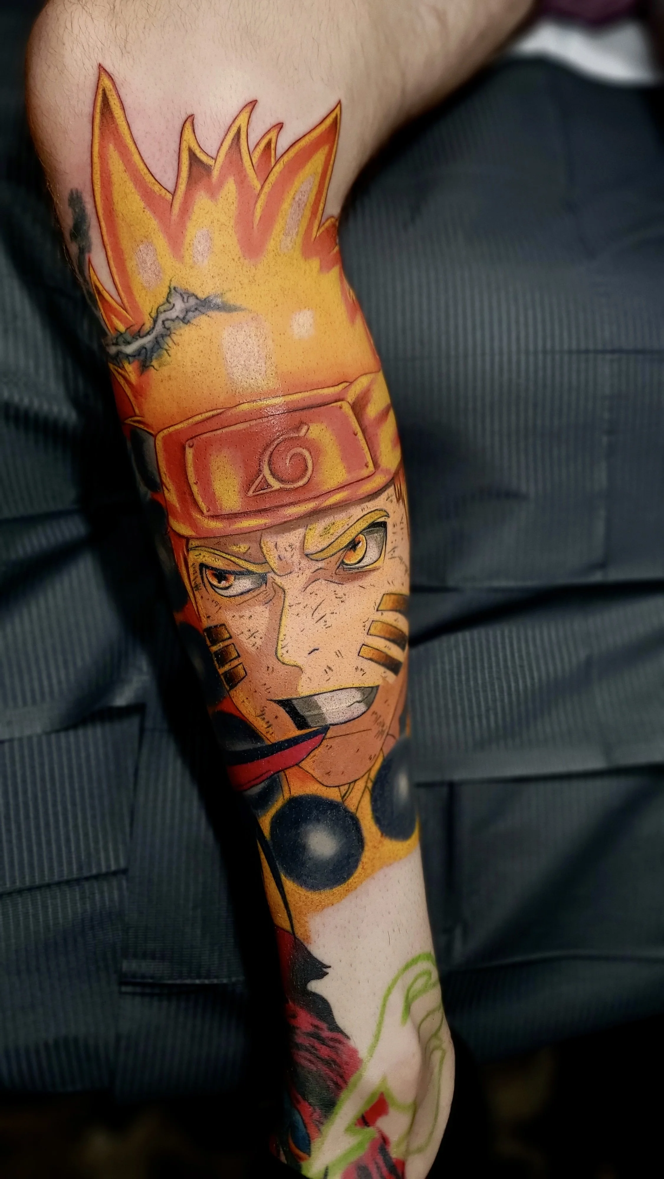 Tattoo of Naruto Uzumaki from the anime Naruto, showing his face with a headband, spiky hair, and determined expression.