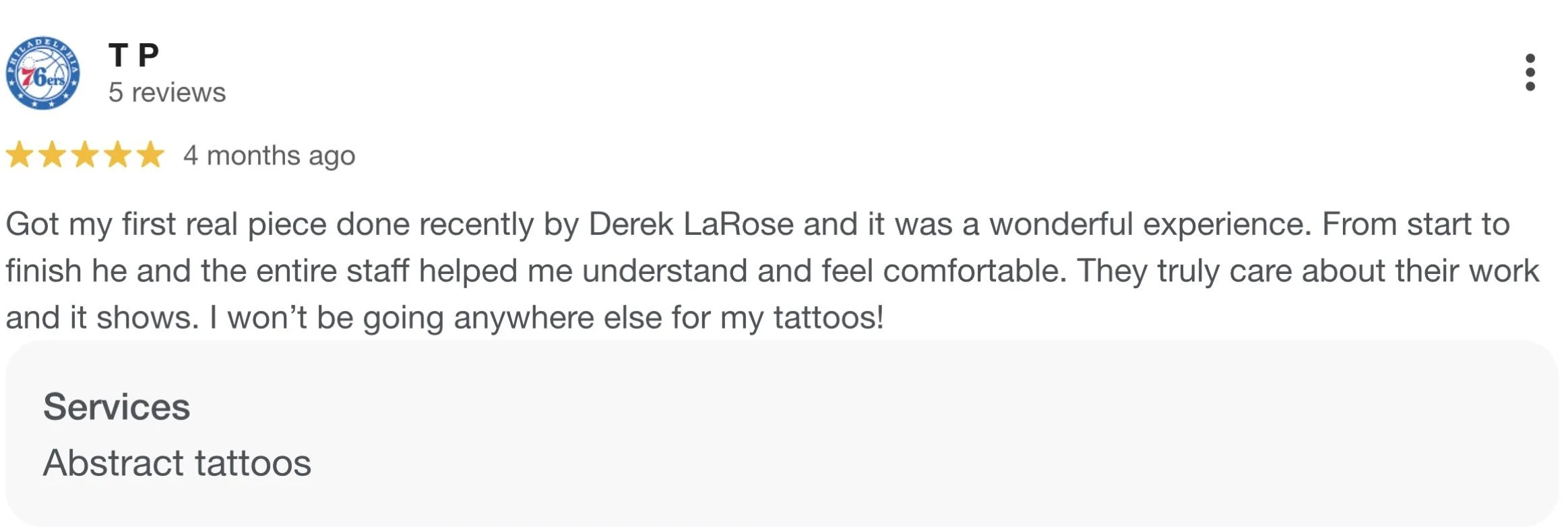 Review for a tattoo artist with a logo of the 76ers basketball team. The review is positive, rating five stars, and mentions a tattoo done by Derek LaRose. The text describes a good experience with the staff's care and professionalism, and states the customer's intent to get more tattoos from this artist.