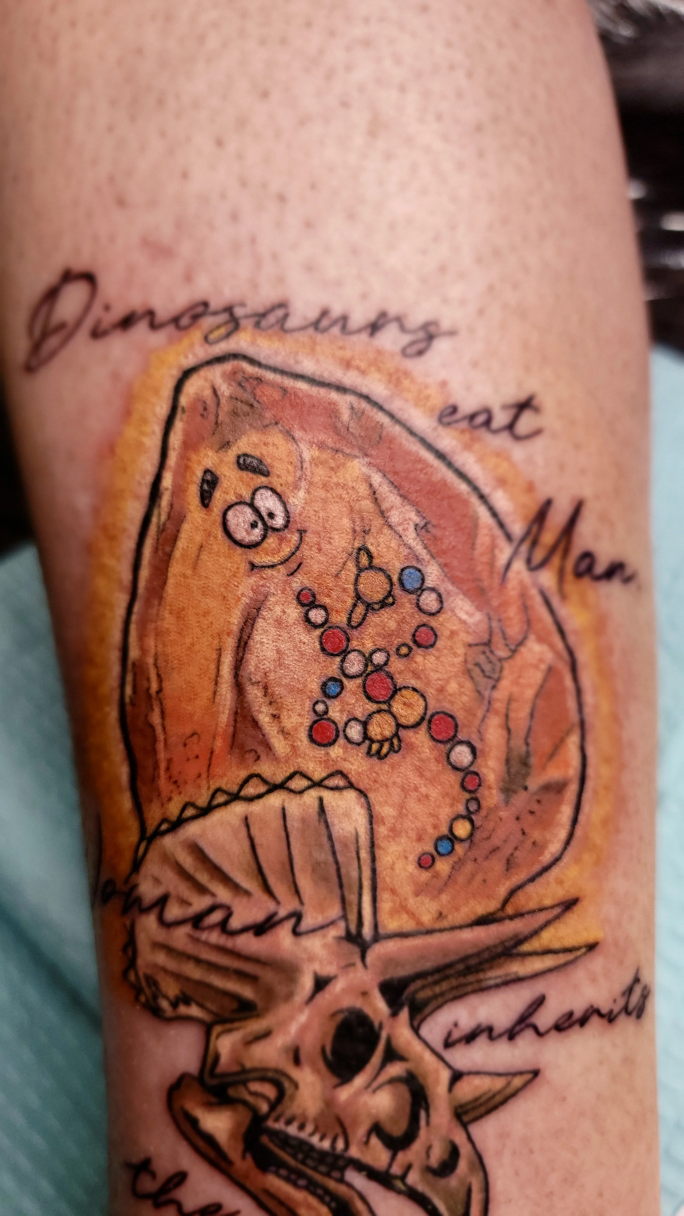 Colorful tattoo of pizza with a face, played with words, and skull designs on a person's arm.
