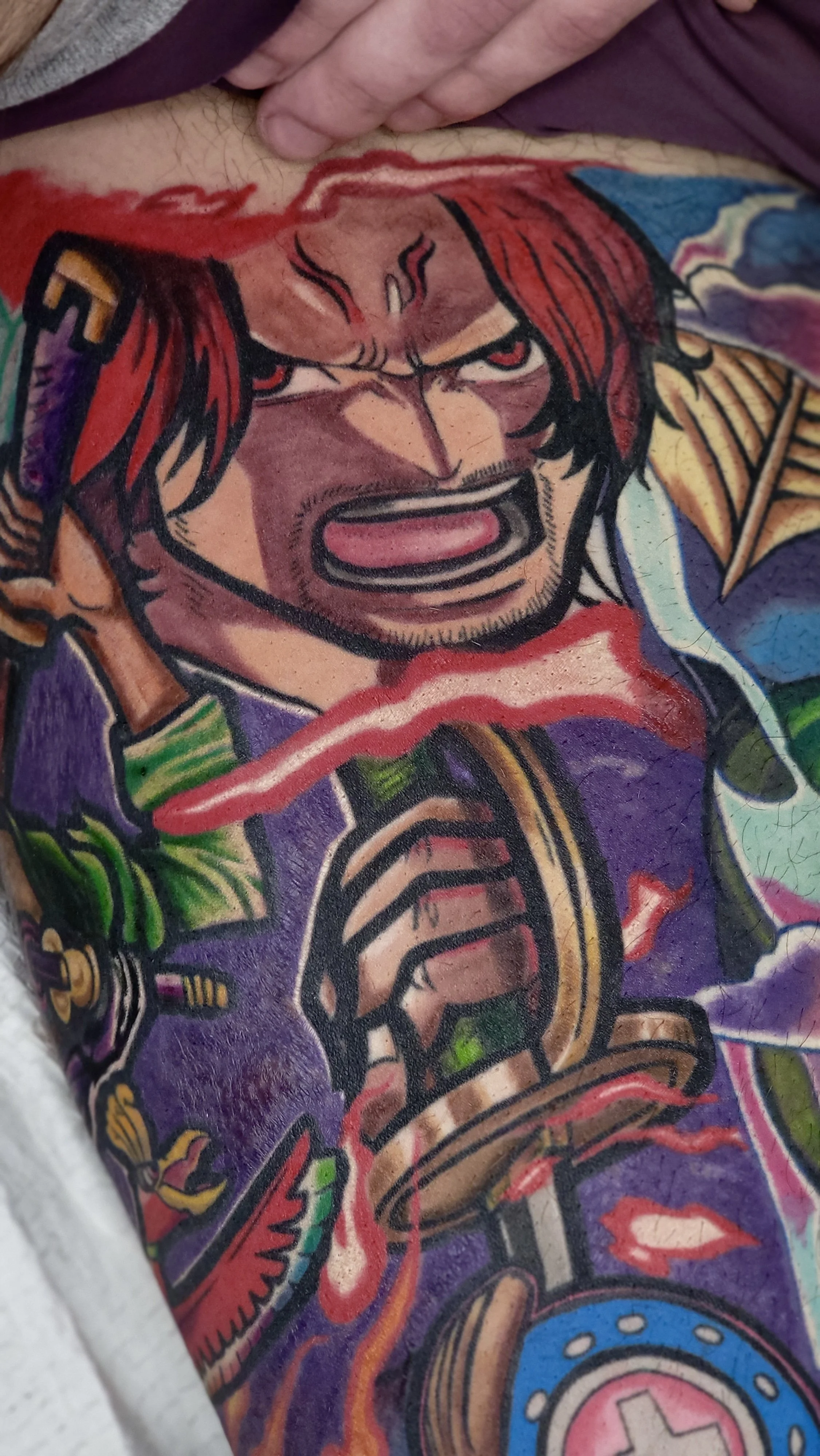 Close-up of a colorful tattoo on a person's arm depicting a fierce warrior with a red beard, armor, and a sword, with vivid colors and bold outlines.