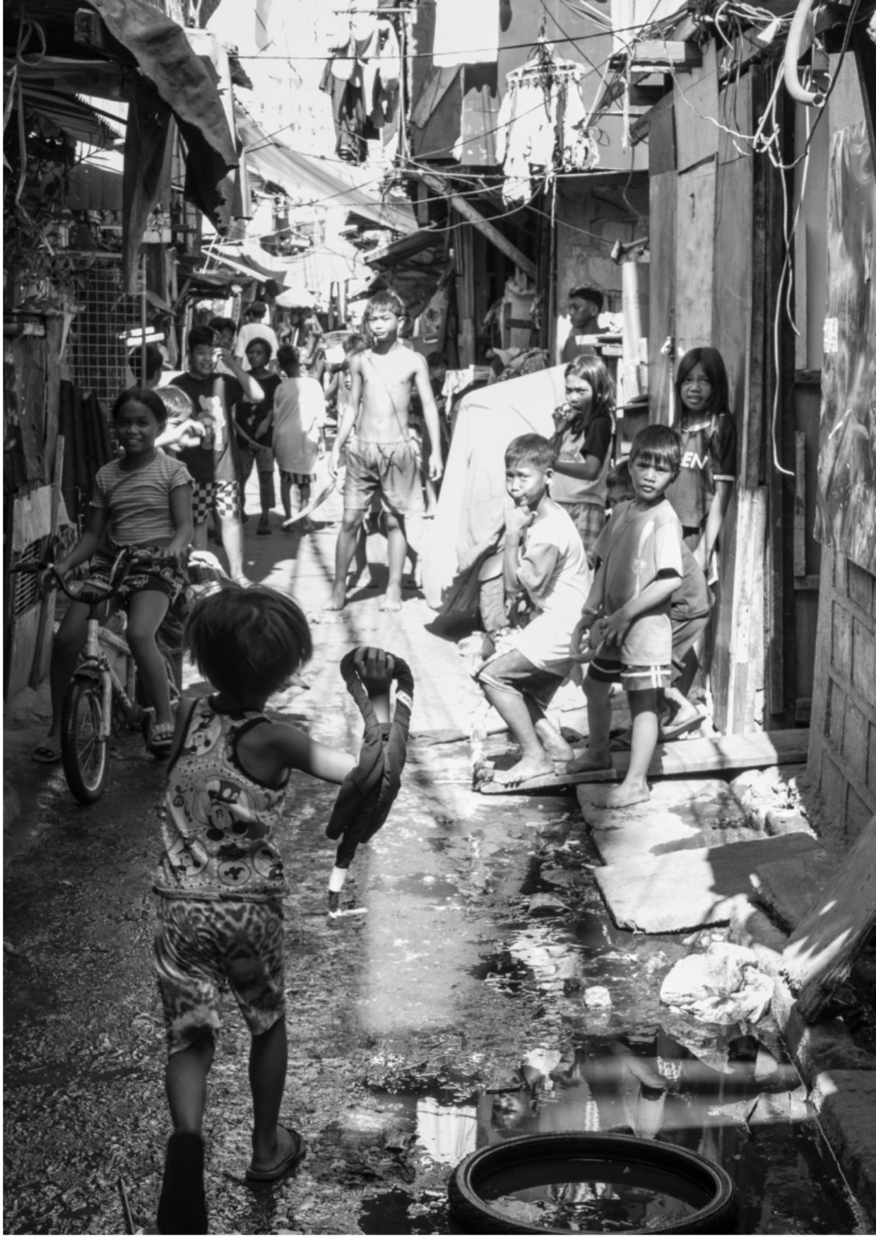Children playing and walking in a narrow alley with makeshift houses in a poor neighborhood in Tondo, Manila ©R. Hartel for odoVita.