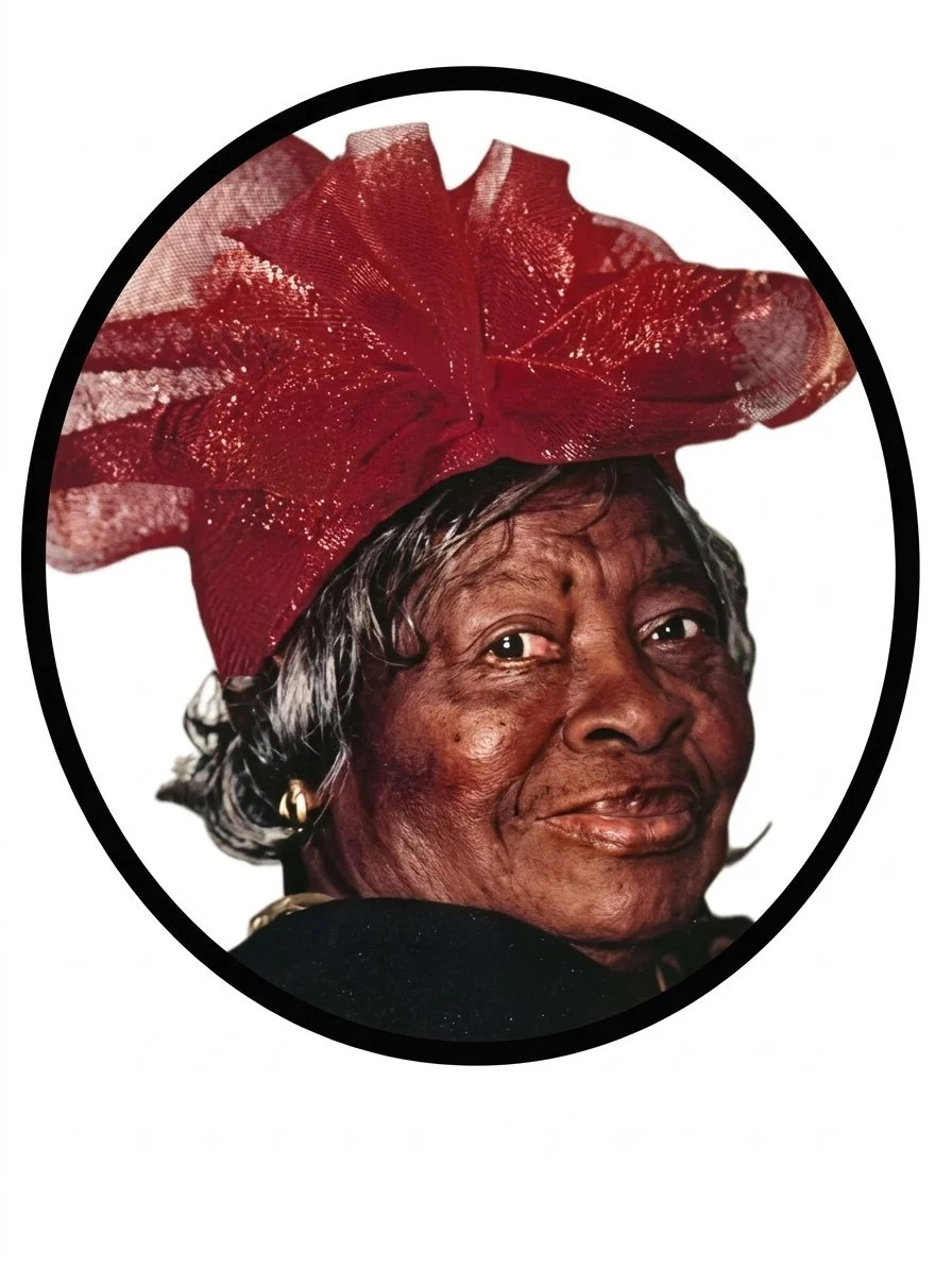 Portrait of an Flossiie Moye Johnson with gray hair wearing a large red decorative hat.