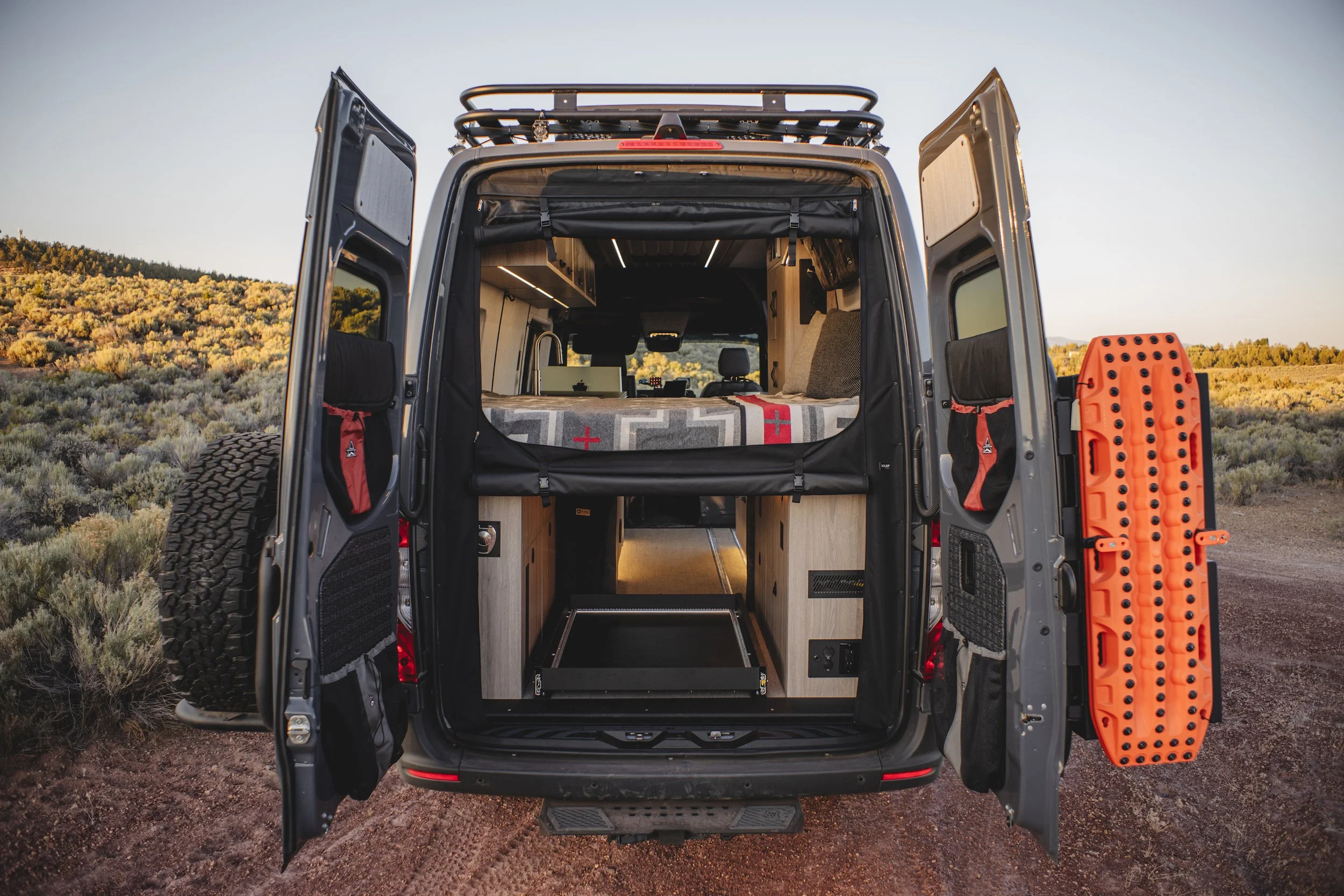 Open rear doors of 'Choices' A 170 Sprinter van, revealing custom-built interior, captured in Central Oregon.